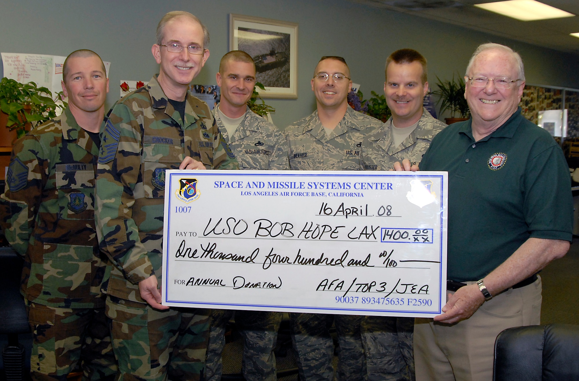 SMC Command Chief Master Sergeant Steven Crocker and members of the LAAFB Top 3, Junior Enlisted Association and AFA presented a $1,400 check to the Bob Hope USO at LAX, April 17. (Photo by Joe Juarez)