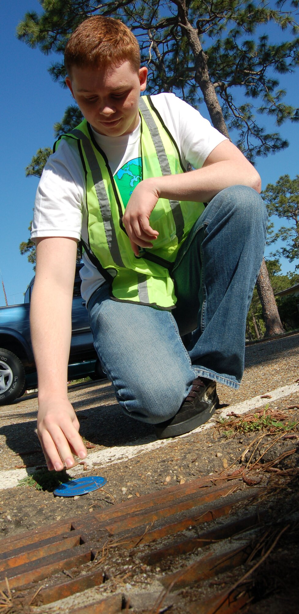 EGLIN AIR FORCE BASE, Fla. -- 
Airman 1st Class Jonathon Wilson, 33d Maintenance Squadron non-destructive inspection journeyman, places a stormwater pollution prevention decal near a storm drain April 17.   Wilson was part of one of three Eglin volunteer teams who placed 153 decals near stormwater drains across Eglin in celebration of Earth Day. (U.S. Air Force photo by Jerron Barnett)
