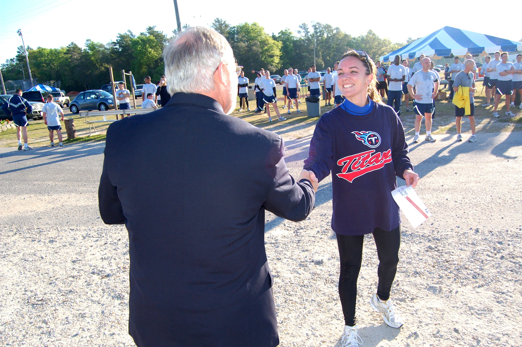 EGLIN AIR FORCE BASE, Fla. -- Michael Applegate, Eglin Environmental Management Division chief, hands the first-place $25 Army and Air Force Exchange Service gift certificate to Summer Leim, 36th Electronic Warfare Squadron F-22 Raptor mission data test director, during the Earth Day 5k Fun Run/Walk event at Foster Stadium April 17.  Ms. Leim was the first woman to cross the finish line with a time of 22:12, followed by 1st Lt. Amber Spurlock, Air Armament Center Staff Judge Advocate (24:55/$15 AAFES gift certificate) and Rhonda Widmaier, 46th Maintenance Squadron (26:30/$10 AAFES gift certificate). (U.S. Air Force photo by Jerron Barnett)