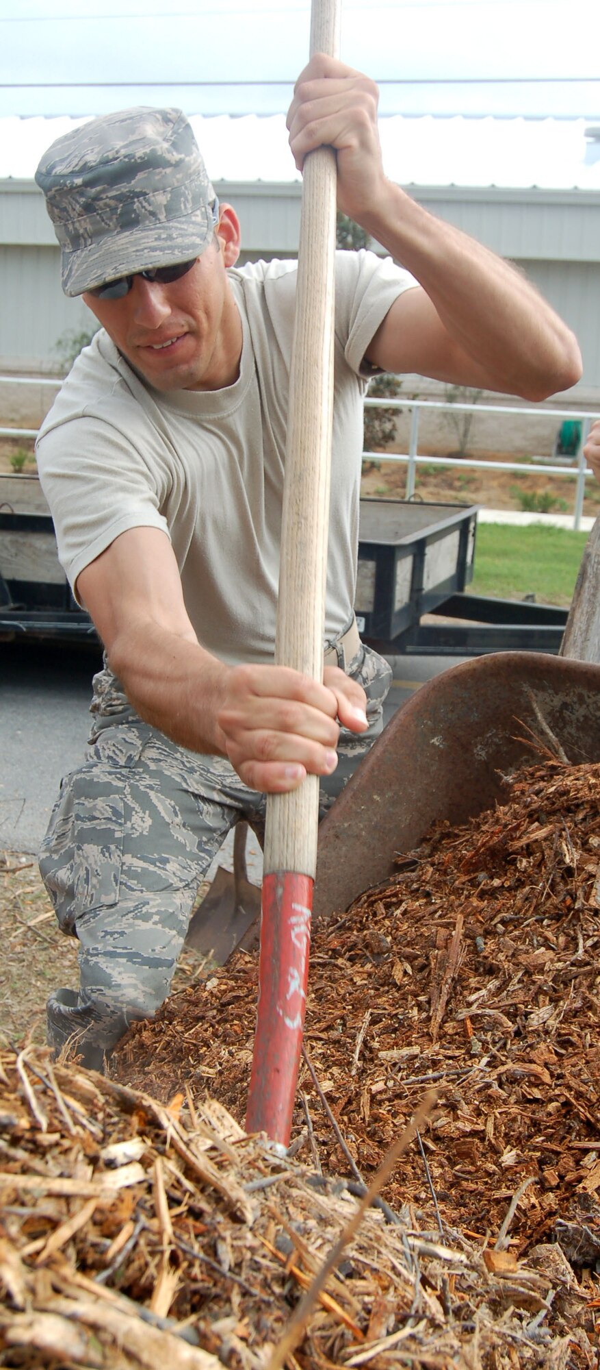EGLIN AIR FORCE BASE, Fla. -- Staff Sgt. Cesar Alvarado, 796th Civil Engineer Squadron structural journeyman, loads mulch into a wheel barrel.  Sergeant Alvarado, Earth Day volunteers and many other  796th CES Airmen participated in the "Florida friendly" landscaping project at Bldg. 670 where they planted 350 native Florida plants which require less irrigation and helps the base conserve water. (U.S. Air Force photo by Jerron Barnett)
