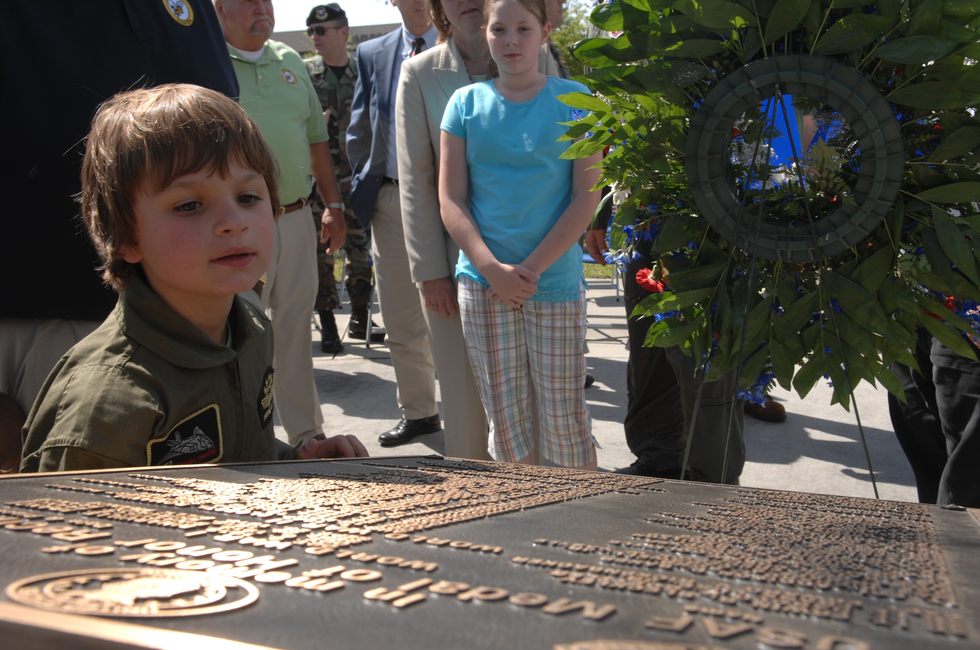 MOODY AIR FORCE BASE, Ga. -- A child dressed in a flight suit looks at a Medal of Honor recipient monument shortly after a re-dedication ceremony for Airman 1st Class William H. Pitsenbarger here April 18. Airman Pitsenbarger was a pararescueman who was posthumously awarded the Congressional Medal of Honor for his heroic acts during the Vietnam war . (U.S. Air Force photo by Airman 1st Class Brittany Barker)