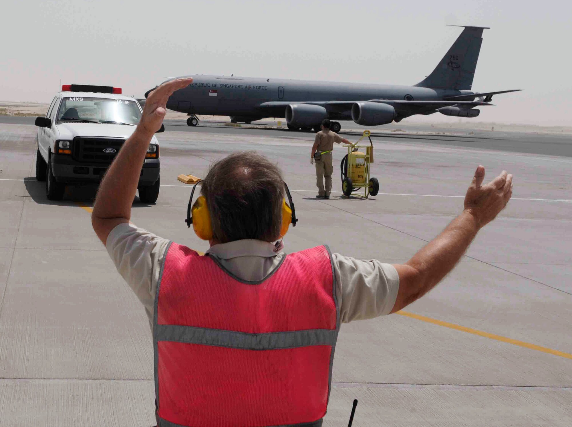 Tom O'Toole performs aircraft recovery for a Singapore air force KC-135 April 16 at a Southwest Asian air base. This is the Singapore air force's 112th Squadron's fifth deployment rotation since 2004. As coalition partners, they integrate with tanker operations in the 379th Air Expeditionary Wing, which account for more than half of the refueling support provided throughout the region. Mr. O'Toole is a 379th Expeditionary Maintenance Squadron transportation and alert specialist. (U.S. Air Force photo/Tech. Sgt. Johnny Saldivar) 
