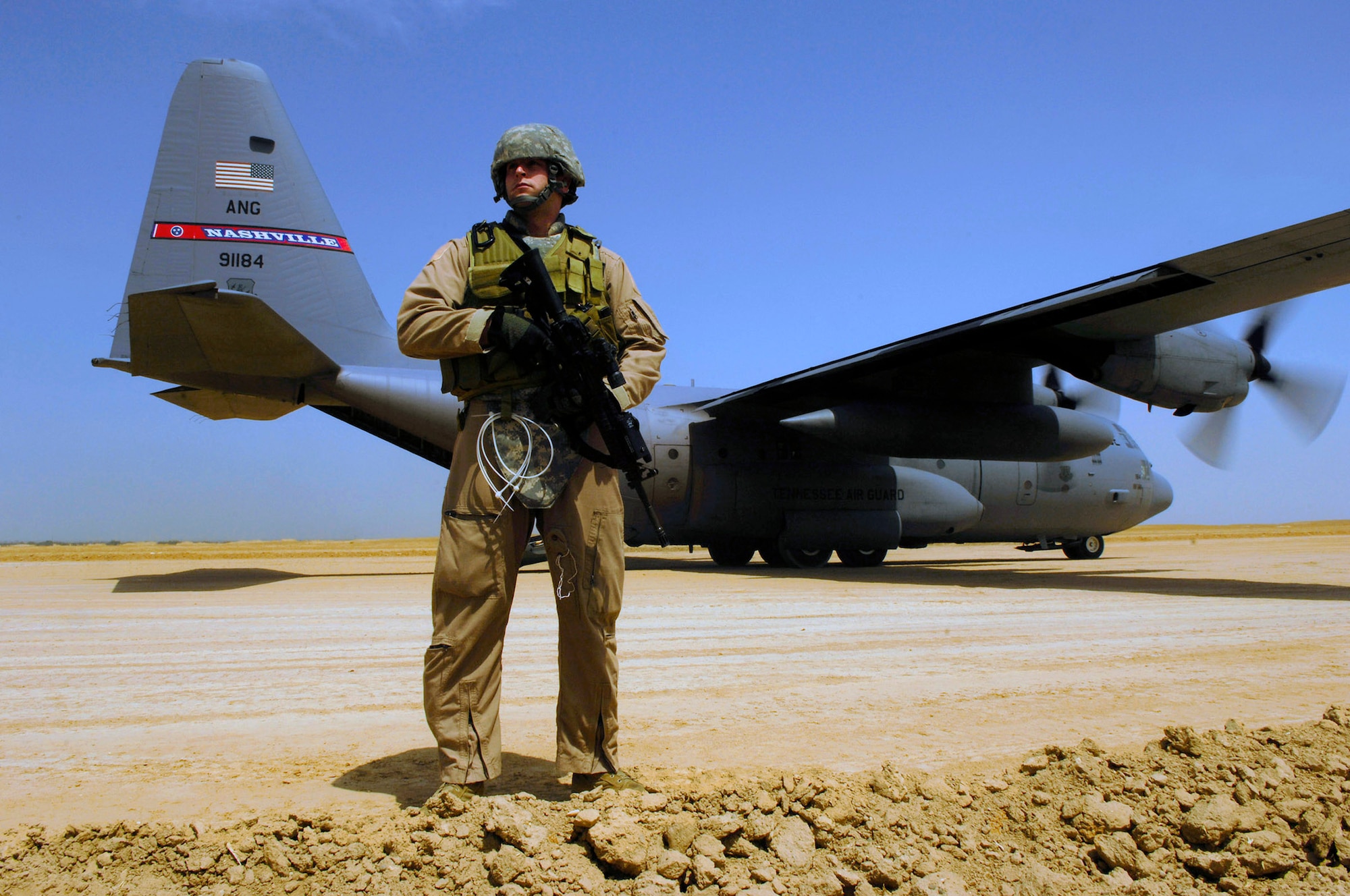 Senior Airman Matt Cooper provides security for a C-130 Hercules aircraft April 18, during a cargo mission in Afghanistan. SrA Cooper is part of a Fly Away Security Forces Team assigned to the 455th Expeditionary Security Forces and deployed from the 355th Security Forces Squadron, Davis-Monthan Air Force Base, Ariz. The C-130 is the prime transport for air dropping troops and equipment into hostile areas. (U.S. Air Force photo/Master Sgt. Andy Dunaway) 