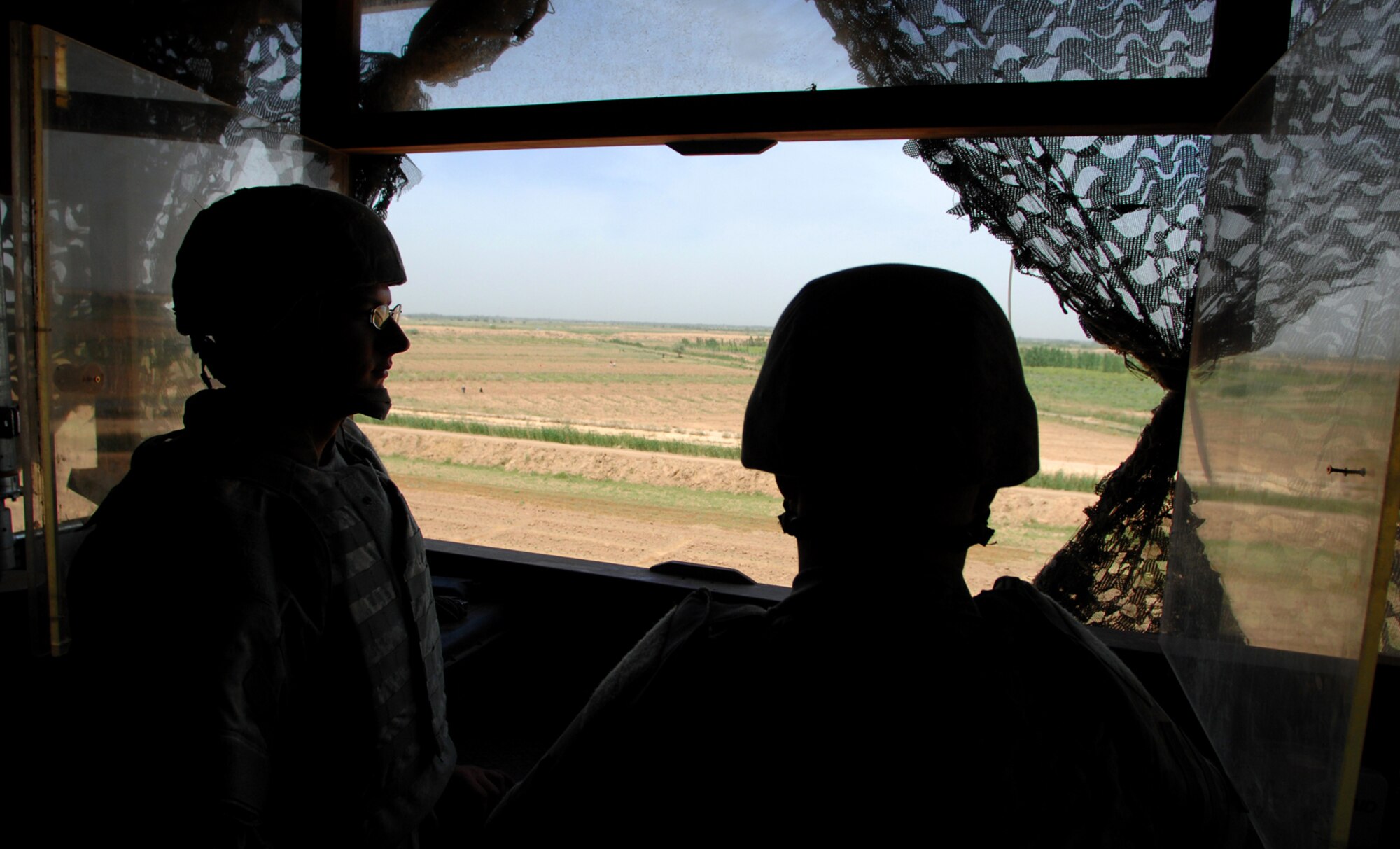 BALAD AIR BASE, Iraq -- Senior Airman Paul Sulak and Airman 1st Class Levi Bilyeu, 332nd Expeditionary Security Forces Squadron listen post observation post, keep watch along the base perimeter for suspicious activities here, April 18. Potential enemy activities are always watched for by the post observers; no shenanigans go unnoticed. Airman Sulak is deployed from McConnell Air Force Base, Kan. (U.S. Air Force photo/ Senior Airman Julianne Showalter)