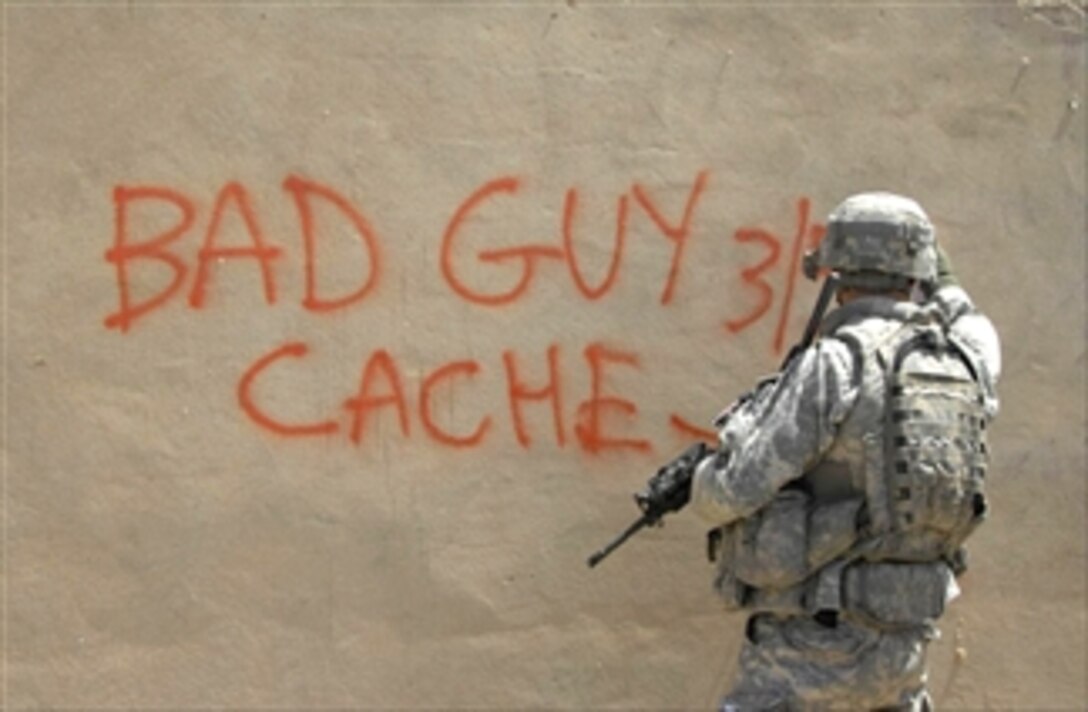 A U.S. Army soldier spray paints the wall to identify a weapons find with "Bad Guy Cache 3-5-2" found by Iraqi soldiers and police near Yarimjah, Mosul, Iraq, April 17, 2008. The U.S. soldier is assiged to the 10th Mountain Division's 5th Battalion, 25th Field Artillary, 4th Brigade.
