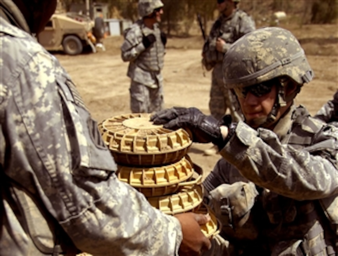U.S. soldiers load ordnance from a weapons cache onto a trailer outside Abu Thayla, Iraq, for later disposal, April 13, 2008. The soldiers are assigned to the 3rd Infantry Division's 3rd Brigade Combat Team.