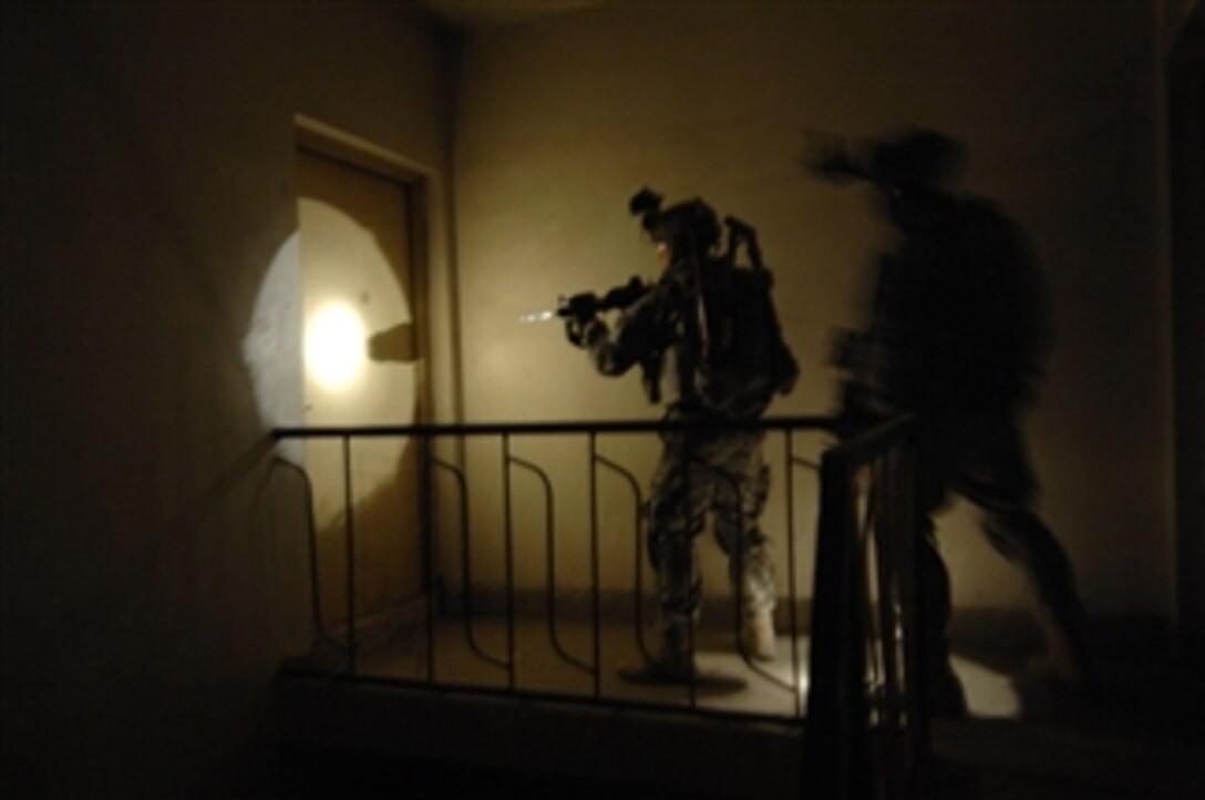 080416-A-6524C-004
	Two U.S. Army soldiers focus on the door revealed in the beam of a flashlight as they prepare to breach the door during a search for weapons caches in Baghdad, Iraq, on April 16, 2008.  The soldiers are from Echo Company, 2nd Squadron, 2nd Stryker Cavalry Regiment.  