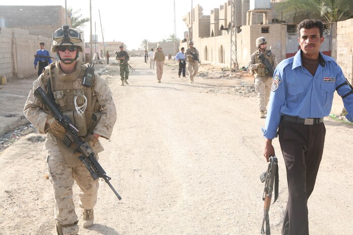 RAMADI, Iraq – Lance Cpl. Matthew D. Nasso, a rifleman with Company A, walks alongside an Iraqi Policemen during a dismounted joint patrol through a neighborhood of Ramadi April 24. (Official U.S. Marine Corps photo by Lance Cpl. Casey Jones) (RELEASED)