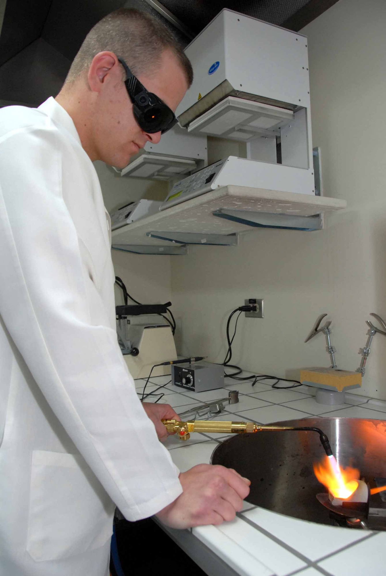 OSAN AIR BASE, Republic of Korea -- Senior Airman Dennis Bermel, 51st Dental Squadron lab technician, uses a blow torch to liquefy gold April 22. The gold is then poured into a stone molding and will be used as a cast. This is the first stage of a two-day process to create a single cast which will be used on a dental patient. (U.S. Air Force photo/Staff Sgt. Lakisha Croley)