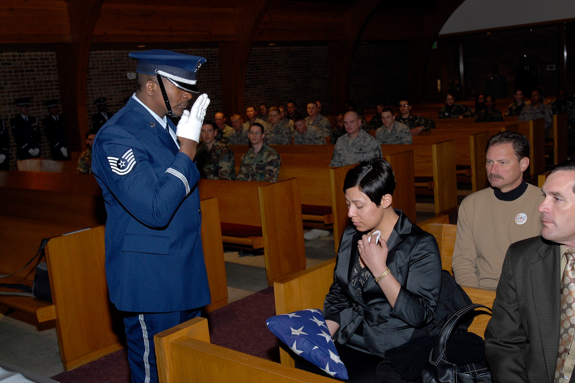 A technical sergeant assigned to the High Frontier Honor Guard salutes a grieving survivor after presenting her a folded American flag during a mock funeral procession for the Air Force-level LeMay inspection team April 10 at the Peterson chapel. The team inspected the 21st Services Squadron April 7-11 to see if they qualified as the “best of the best” of services squadrons throughout the Air Force. (U.S. Air Force photo/Rob Lingley)