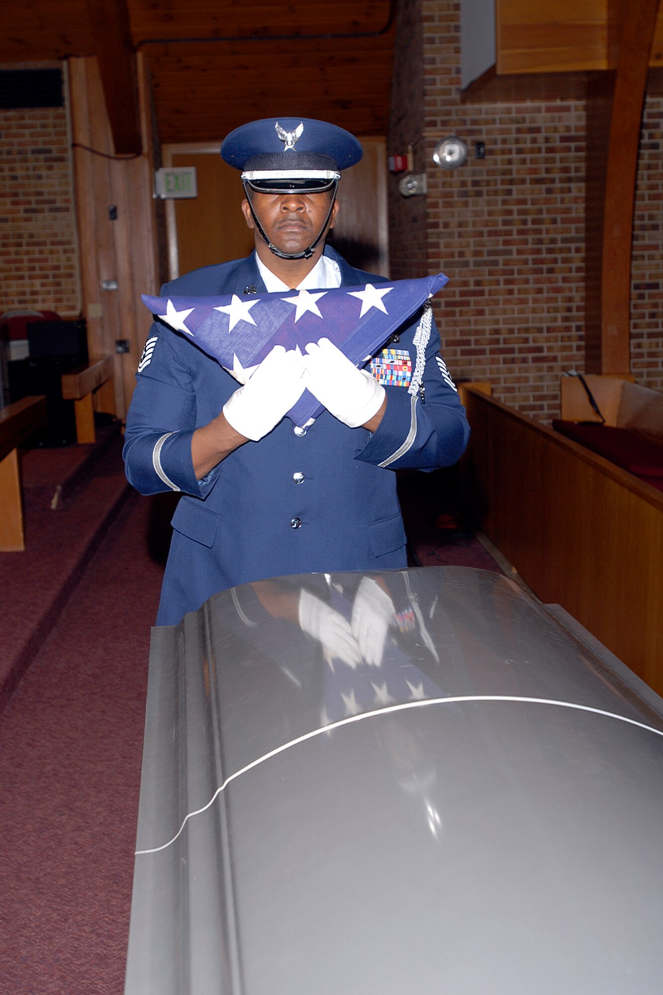 A technical sergeant assigned to the High Frontier Honor Guard prepares to present a folded American flag to a grieving survivor during a mock funeral procession for the Air Force-level LeMay inspection team April 10 at the Peterson chapel. The team inspected the 21st Services Squadron April 7-11 to see if they qualified as the “best of the best” of services squadrons throughout the Air Force. (U.S. Air Force photo/Rob Lingley)