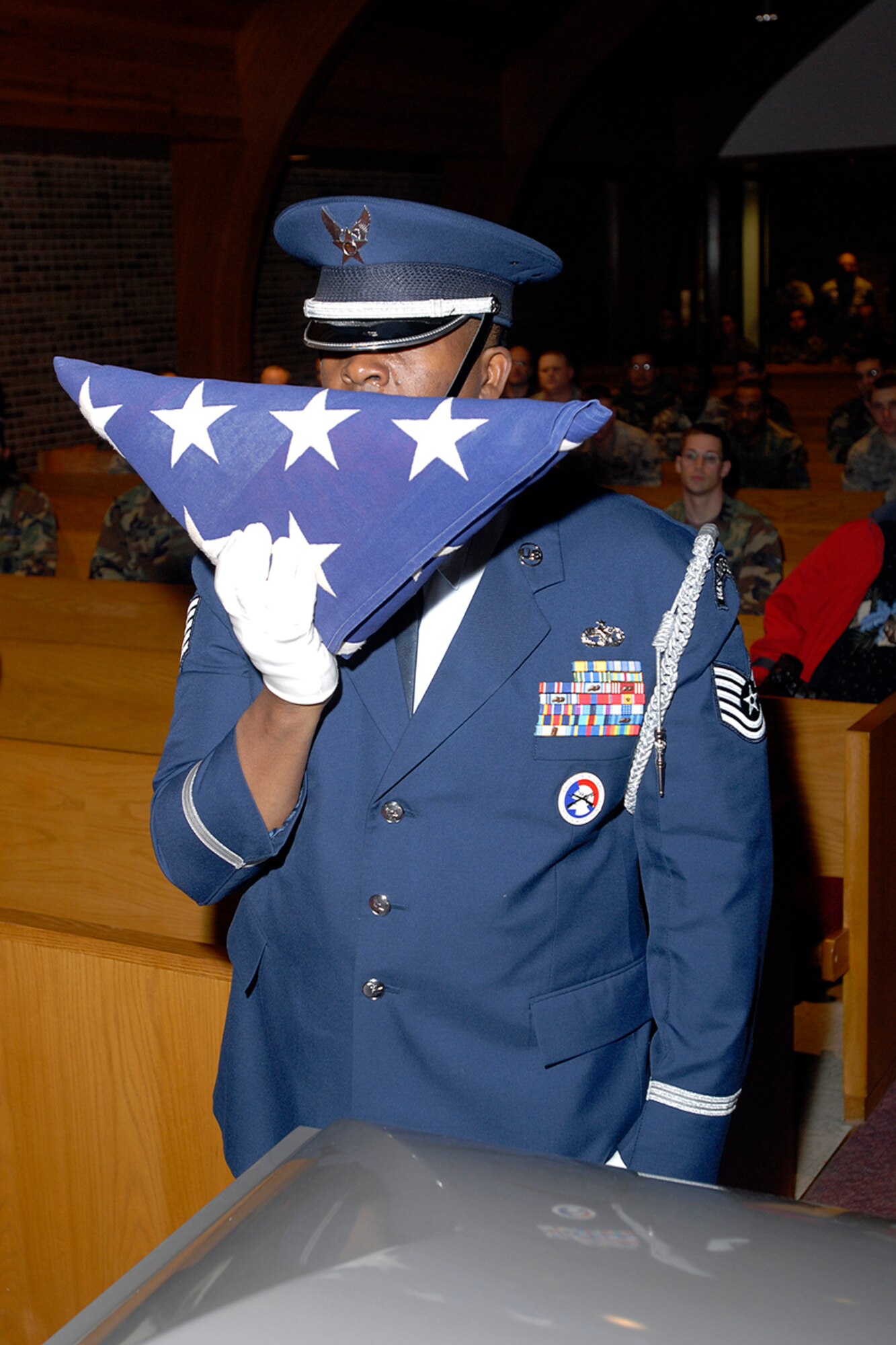 A technical sergeant assigned to the High Frontier Honor Guard prepares to present a folded American flag to a grieving survivor during a mock funeral procession for the Air Force-level LeMay inspection team April 10 at the Peterson chapel. The team inspected the 21st Services Squadron April 7-11 to see if they qualified as the “best of the best” of services squadrons throughout the Air Force. (U.S. Air Force photo/Rob Lingley)