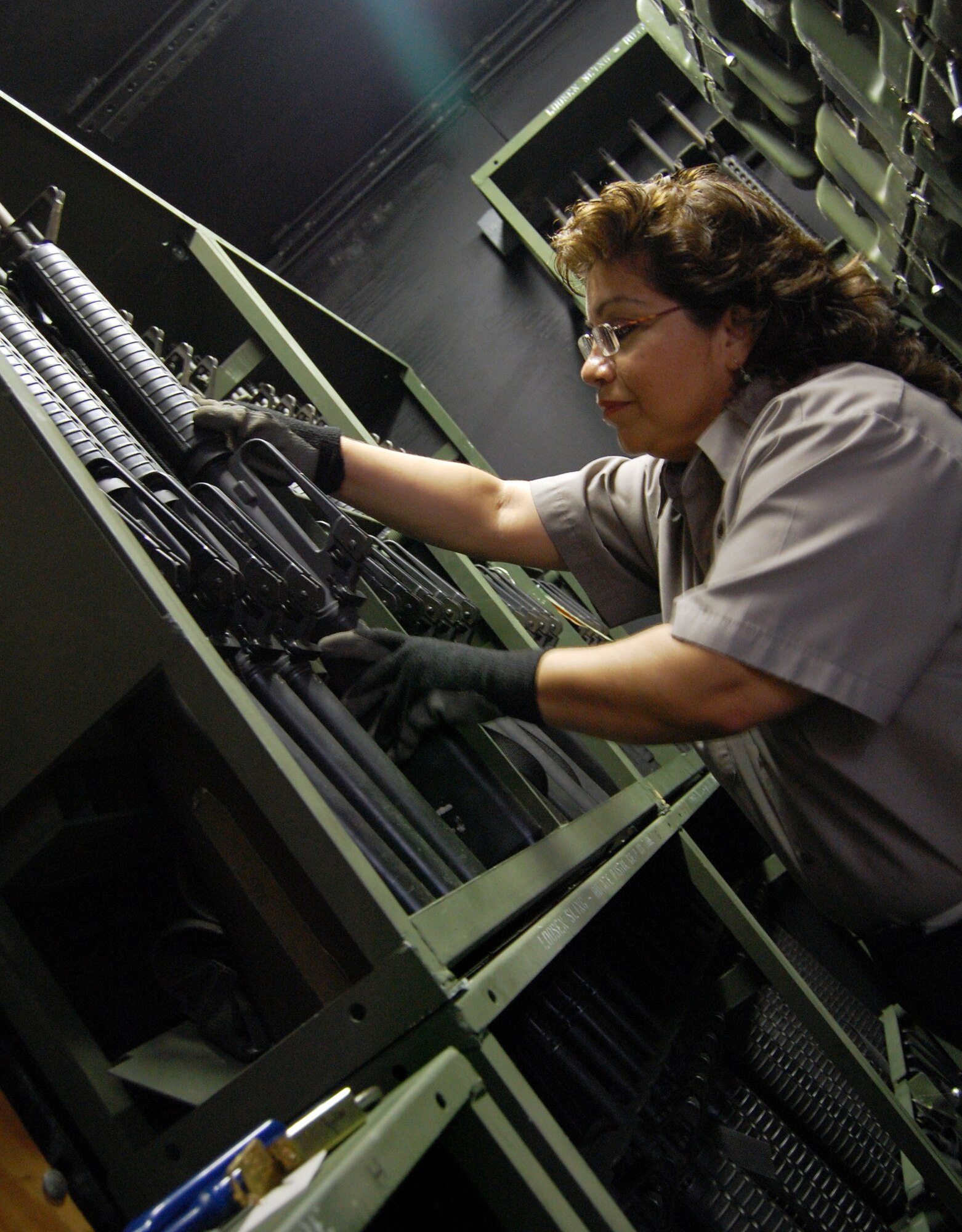 LAUGHLIN AIR FORCE BASE, Texas – Elma Garcia, mobility stock clerk with the 47th Mission Support Group, returns an M-16 to its rack in a safe at the mobility supply shop here April 22. The mobility supply shop provides military members with equipment such as gas masks, canteens, chemical response gear, weapons and a variety of other equipment for training purposes and deployments all over the world. “Sometimes this job can be very interesting,” said Garcia.  “I like knowing that I get to help prepare servicemembers for their deployments.”  (U.S. Air Force Photo by Airman First Class Sara Csurilla)