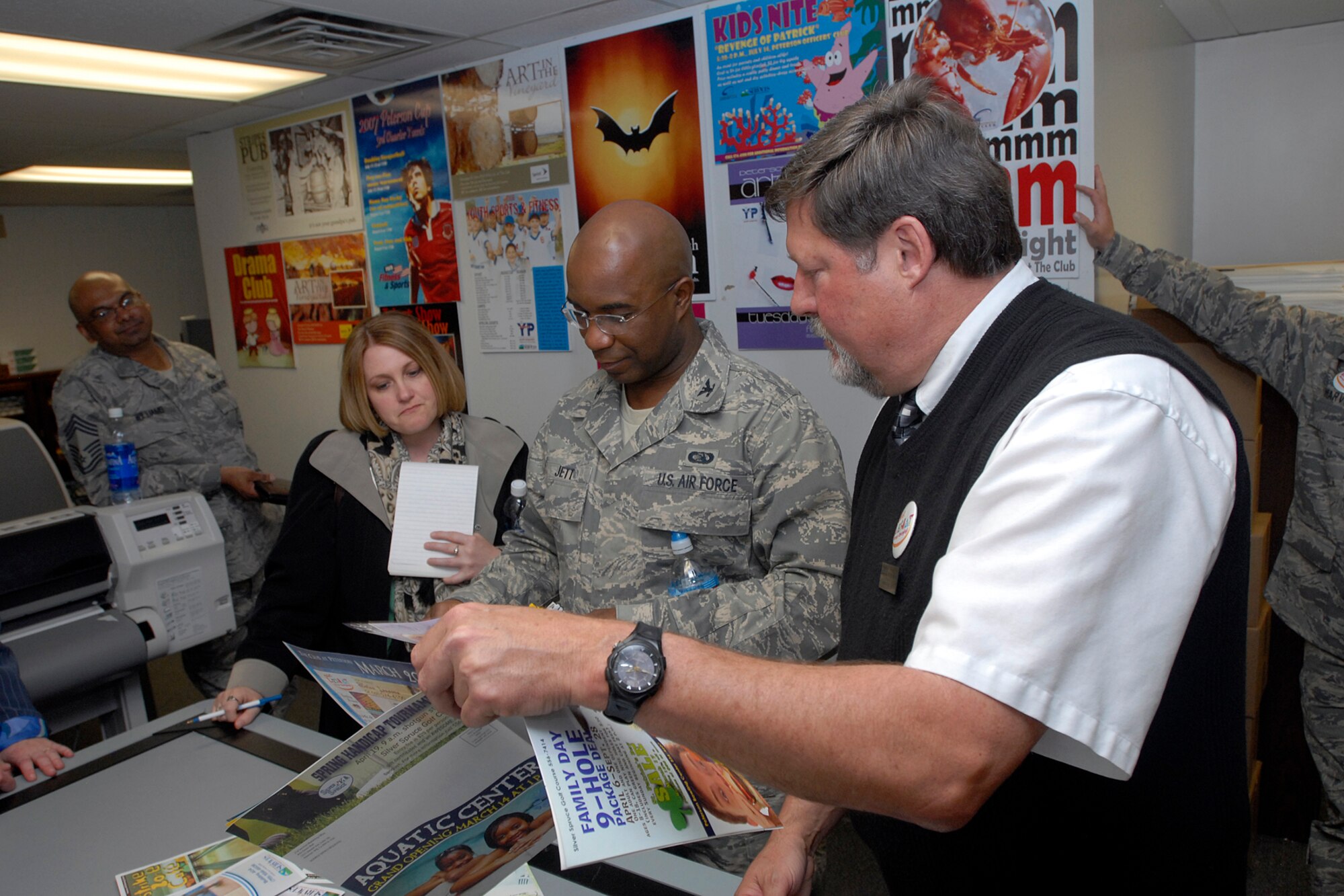 Warren Schroeder briefs Col. Herman Jett and other Air Force-level LeMay award inspectors on the different publicity products created by the 21st SVS marketing office April 9 on Peterson Air Force Base, Colo. The team inspected the 21st Services Squadron April 7-11 to see if they qualified as the “best of the best” of services squadrons throughout the Air Force. (U.S. Air Force photo/Larry Hulst)