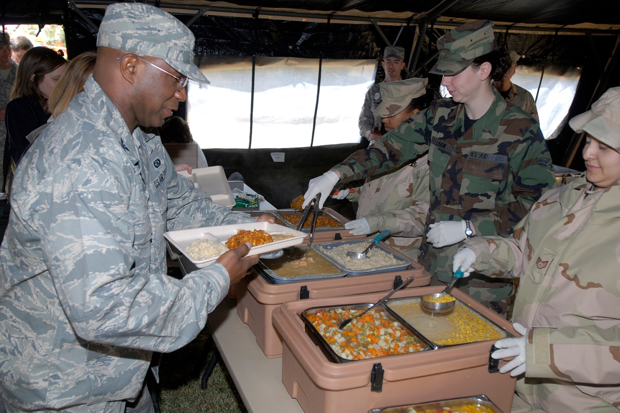 Personnel from the 21st Services Squadron readiness section serve expeditionary lunches to Col. Herman Jett and the Air Force-level LeMay award inspectors using a mobile kitchen April 9 on Peterson Air Force Base, Colo. The team inspected the 21st Services Squadron April 7-11 to see if they qualified as the “best of the best” of services squadrons throughout the Air Force. (U.S. Air Force photo/Larry Hulst)