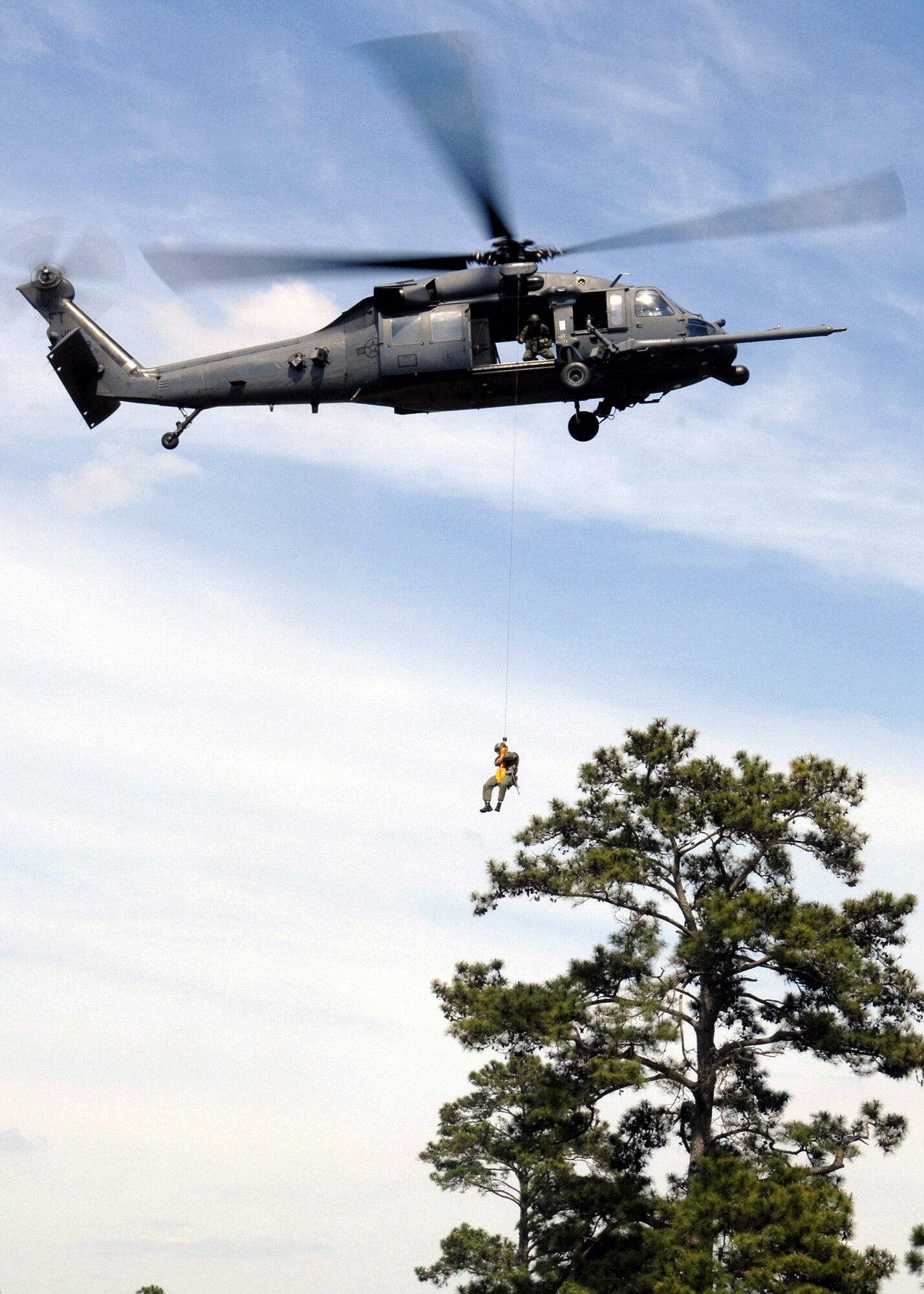 An Airman from the 38th Rescue Squadron rappels from an HH-60G Pave Hawk dressed in a Vietnam-era style uniform during a Medal of Honor ceremony for Airman 1st Class William H. Pitsenbarger at Moody Air Force Base, Ga., April 18. Airman Pitsenbarger was a pararescueman who died in battle on April 11, 1966, and was posthumously awarded the Air Force Cross and later the Medal of Honor. (U.S. Air Force photo/Airman 1st Class Brittany Barker) 