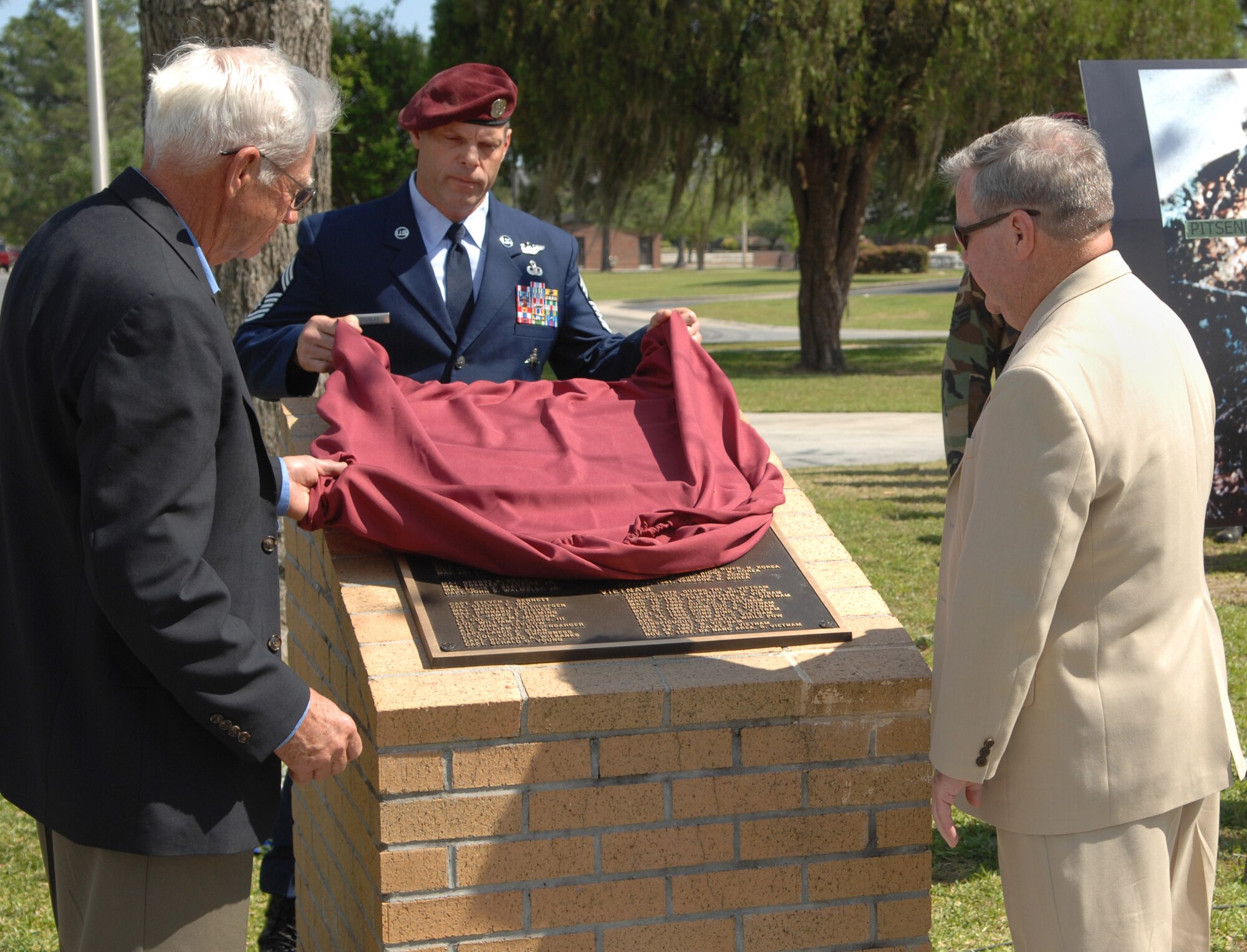Chief Master Sgt. Brian Douglas unveils the monument with retired Chief Master Sgt. Dave Milster and retired Lt. Col. Harry Obeirne, dedicated to the men and women in the Air Force who were recipients of the Medal of Honor at Moody Air Force Base, Ga., April 18. Colonel Obeirne participated in the recovery of the body of Airman 1st Class William Pitsenbarger, after his death. Chief Milster, a pararesuceman, participated in Airman Pitsenbarger's final mission in Vietnam April 11, 1966. Chief Douglas is the 38th Rescue Squadron superintendent. (U.S. Air Force photo/Senior Airman Angelita Lawrence) 