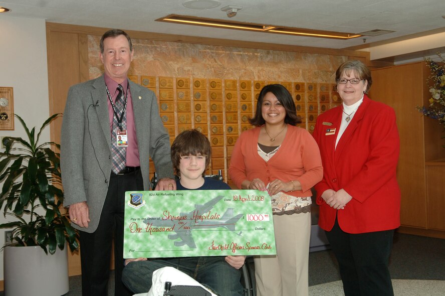 SPOKANE, Wash. – The Fairchild Officers Spouses Club made a $1,000 donation to Shriners Hospitals for Children - Spokane here April 18. Hospital administrator Gene Raynaud and Shriners patient Damion Moore, 11, accept the donation from OSC charitable treasurer Marissa Glassburner and OSC president Jan Wood. Every donation is “really important to us because that’s how we run our operations, through donations and philanthropy – we don’t bill anybody,” said Mr. Raynaud, a retired Air Force colonel, adding that the average cost per child is $10,000. “This money will go right back into things the children need like equipment and healthcare necessities,” he said. (U.S. Air Force photo / Senior Airman Chad Watkins)