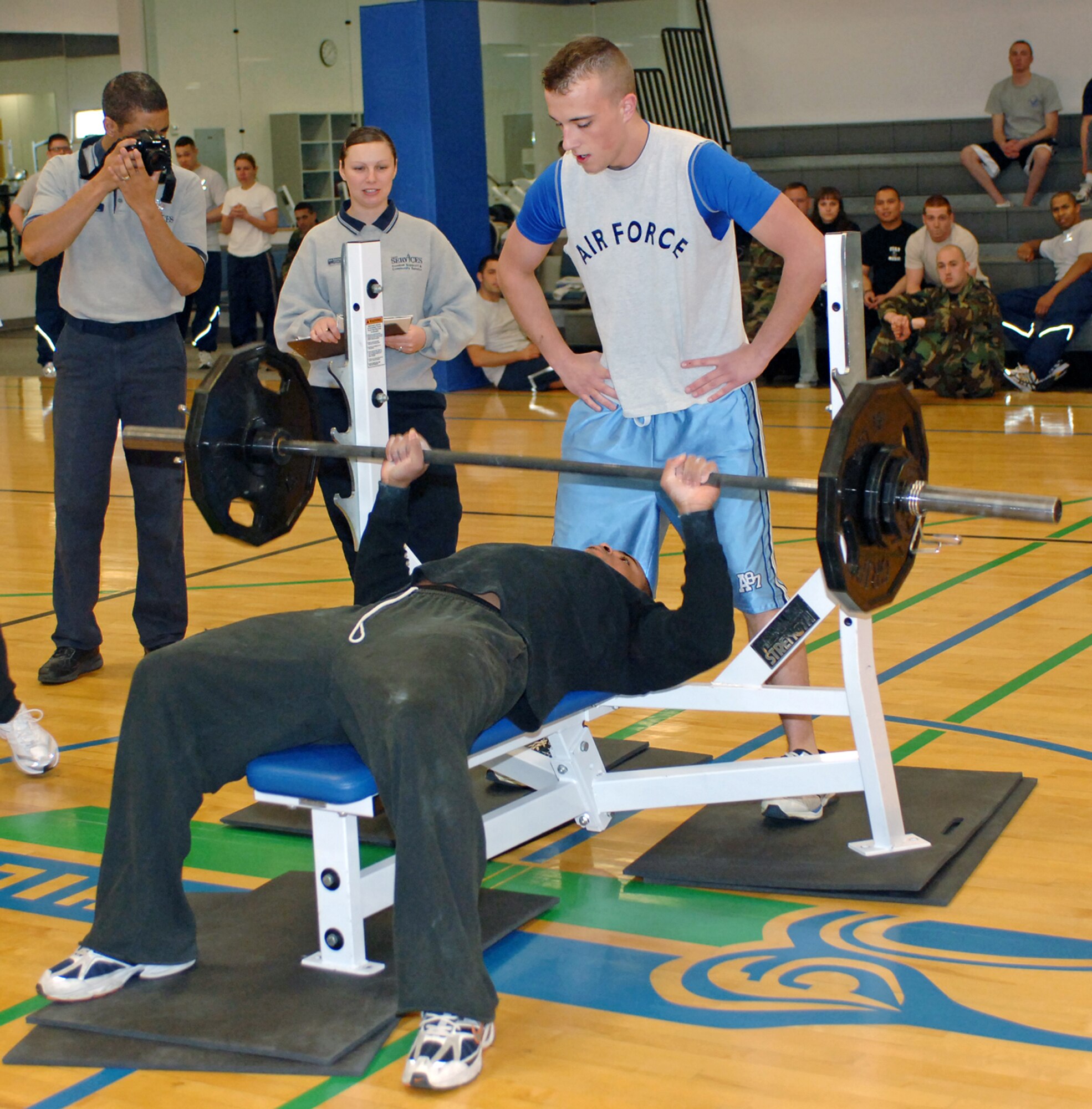 FAIRCHILD AIR FORCE BASE, Wash. -- Airman 1st Class Josh Williams, 92nd Comptroller Squadron financial management member, spots Senior Airmen Steven Hall, 92nd Services Squadron, at a Bench Off at the base fitness center April 21. Their team’s combined strength and enthusiasm placed them third in the competition. (U.S. Air Force photo / Airman 1st Class Melissa Barnett)
