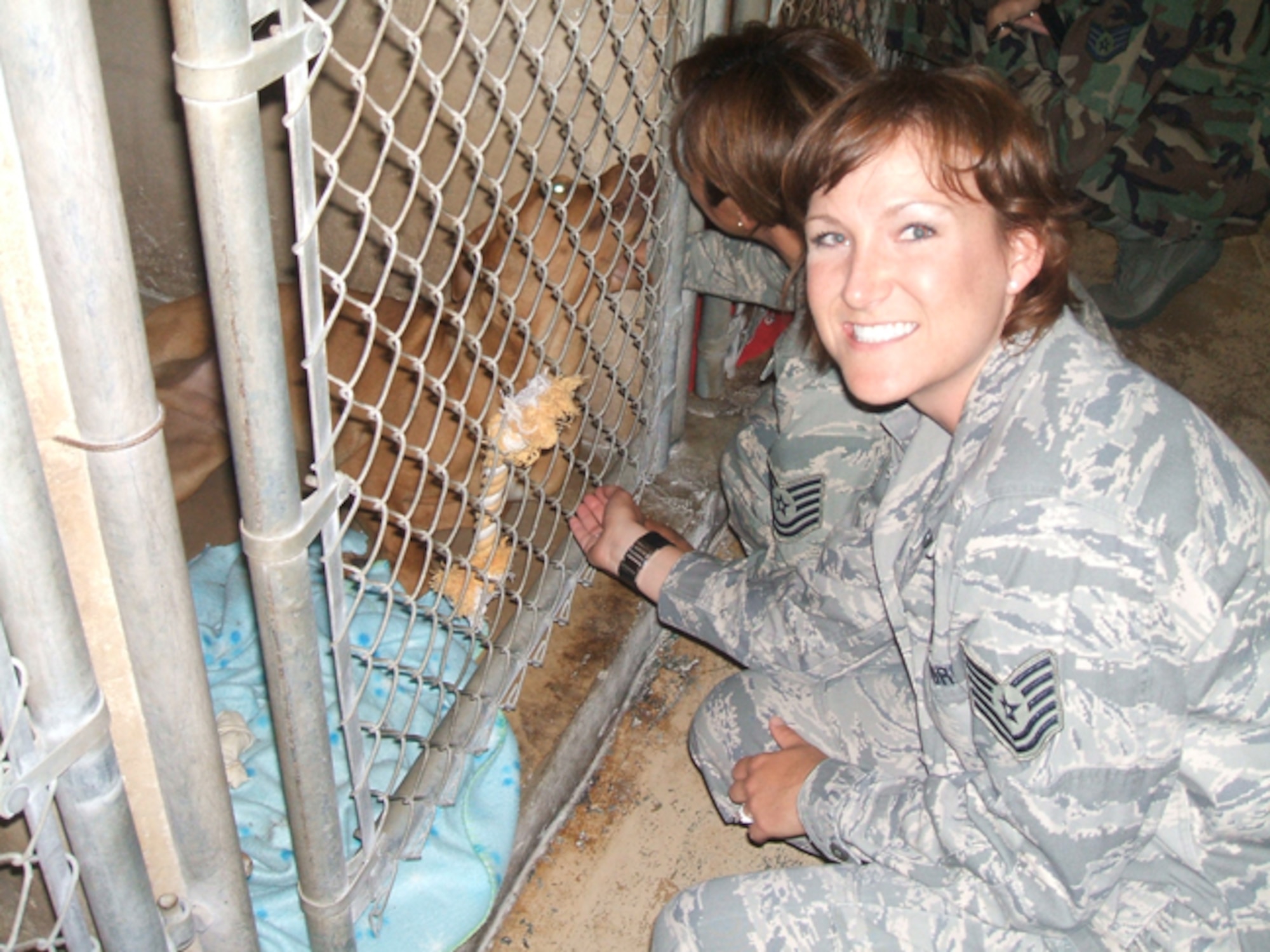 Tech. Sgt. Sandra Deason (facing camera) and Tech. Sgt. Sara Montes visit with one of the animals at the Universal City Animal Shelter after delivering supplies donated by members of the Air Force Personnel Center. (U.S. Air Force photo/File)