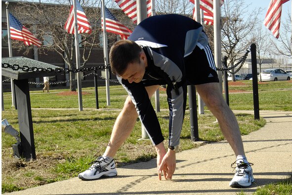 Capt. Brad Panton, program manager for the Enhanced Regional Situation Awareness Program at Hanscom Air Force Base, Mass., stretches before a run in preparation for the Boston Marathon. Capt. Panton ran the marathon with his two siblings, Army Capt. Jeannie Deakyne and Navy Lt. Davie Panton. (Air Force photo by Linda LaBonte Britt)