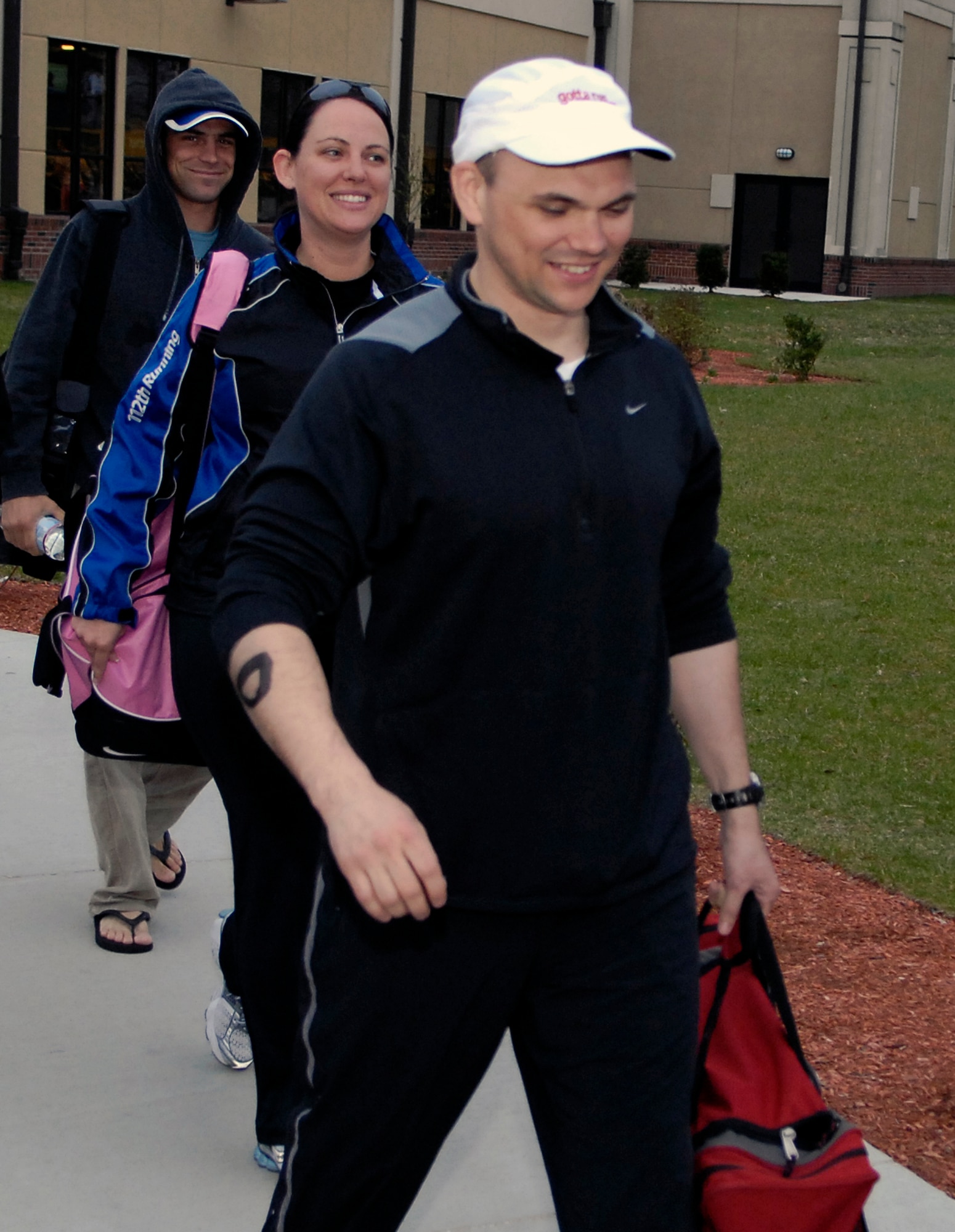 HANSCOM AFB, Mass. – Capt. Brad Panton (front), Program Manager for the Enhanced Regional Situation Awareness Program here, and siblings Army Capt. Jeannie Deakyne (center) and Navy Lt. Davie Panton, board a bus from the Fitness and Sports Center for the Boston Marathon April 21. Due to deployments and being geographically separated, the three of them decided to run the marathon together, after not seeing each other for close to a year. (U.S. Air Force photo by Mark Wyatt.)