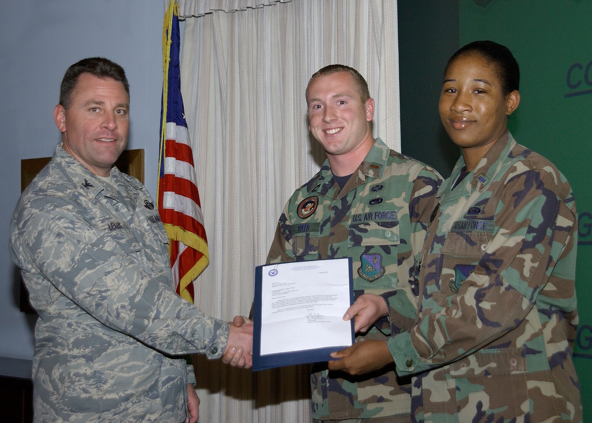 CANNON AIR FORCE BASE N.M.-- Col.Timothy Leahy, 27th Special Operation Wing commander, presents 2nd Lt. Matt Speed, 27th Special Operations Maintenance Operations Squadron, and 1st Lt. Richelle Bartlett, 27th Special Operations Equipment Maintenance Squadron, with awards for outstanding CGOC for the month of January and March.  The award was presented during the weekly staff meeting April 22.  (U.S. Air Force photo/Airman Maynelinne De la Cruz)  