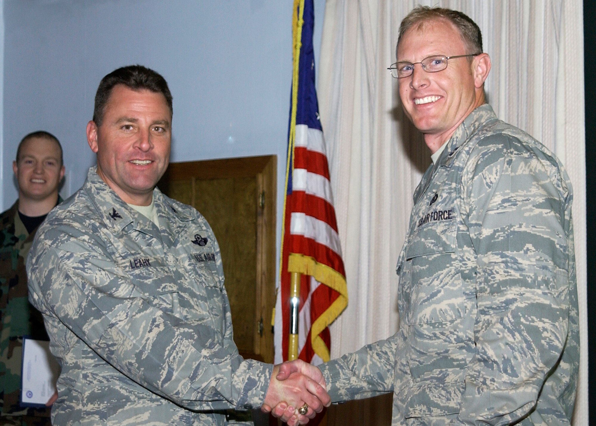 CANNON AIR FORCE BASE, N.M.-- Capt. William Kostan, 27th Special Operations Support Squadron, accepts the 2008 Commander in Chief's Installation Excellence Award (special recognition) on behalf of Senior Airman John Castle, 27th SOSS, and Master Sgt. Garet Vannes, 27th Special Operations Civil Engineer Squadron. The award is presented by Col. Timothy Leahy, 27th Special Operations Wing commander, April 22, during the weekly staff meeting.  (U.S. Air Force photo/Airman Maynelinne De la Cruz)  
