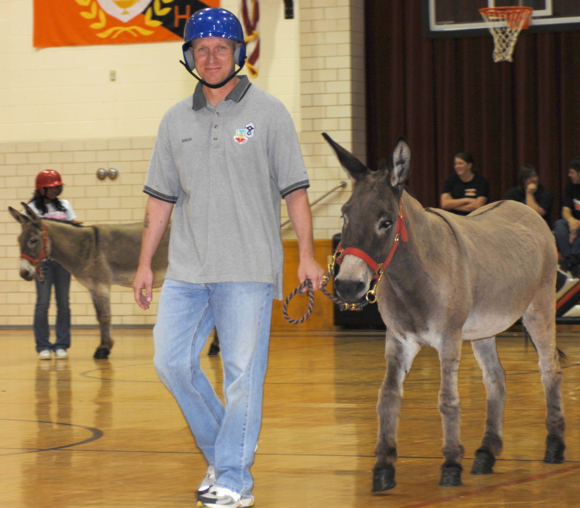 KNOB NOSTER, Mo. - Chief Master Sgt. Brian Hornback, 509th Bomb Wing command chief, escorts his transportation onto the basketball court during player introductions April 19 at Knob Noster High School in Knob Noster, Mo. Chief Hornback represented Whiteman AFB for a local community team during a Donkey Basketball fundraiser for the Knob Noster high School Athletic Booster Club. The community team finished fourth out of four teams during the tournament.(U.S. Air Force photo/1st Lt. Matthew Miller)

