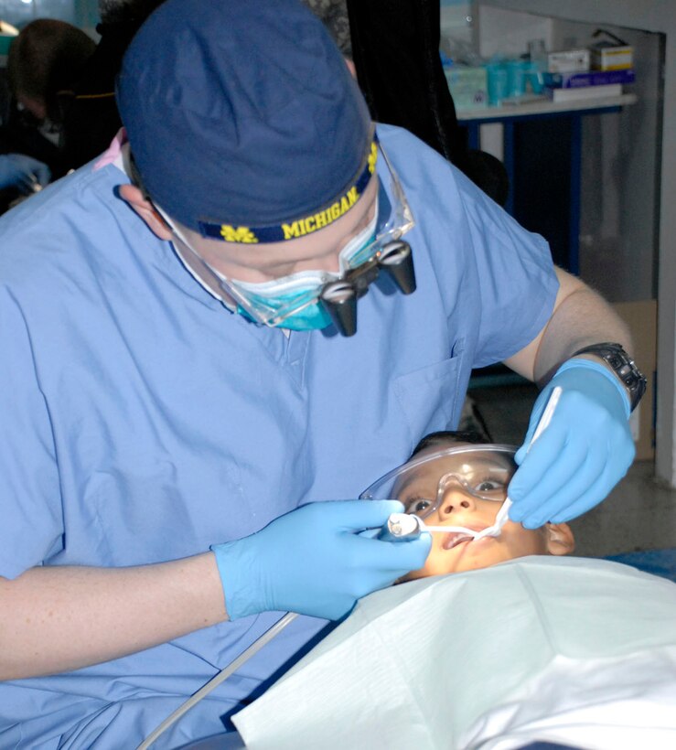 SOTO CANO AIR BASE, Honduras--Army Capt. (Dr.) Christopher Kittle examines the teeth child during a military dental readiness training exercises (DETRETE) at Catholic University?s dental school in Tegucigalpa April 18. For the last eight years Army dental teams have come to Honduras working the DENTRETE, a U.S. Southern Command staple event arranged and supported by Joint Task Force-Bravo. (U.S. Air Force photo by Tech. Sgt. William Farrow)