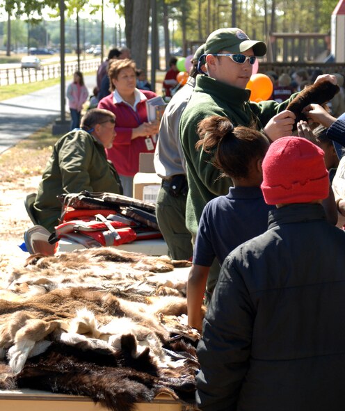 Shelby Staten, U.S. Corps of Engineers, shows a group of children different pelts of fur from local animals. (U.S. Air Force photo by Airman Josh Harbin)