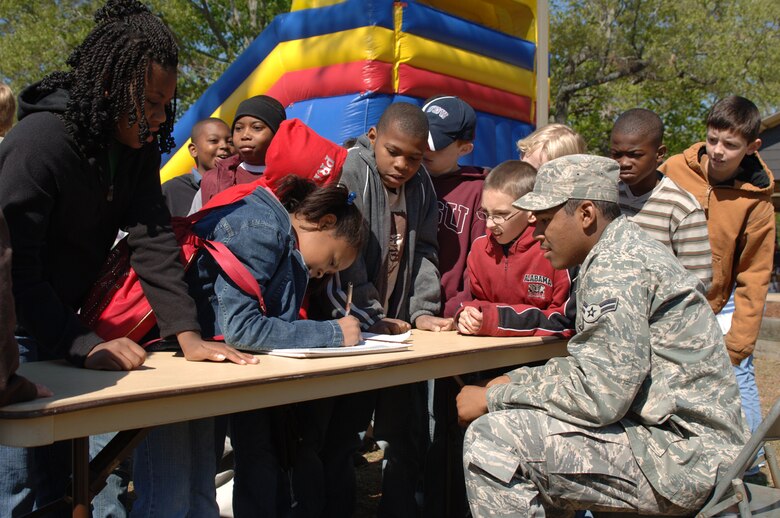 Airman 1st Class Marquis Skinner, 14th Communications Squadron, runs a stand at the Earth Day celebration where children can guess the weight of a bale of plastic bottles weighing in at over 600 lbs. (U.S. Air Force photo by Airman Josh Harbin)