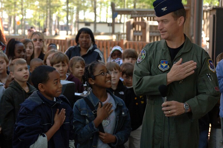Col. Dave Gerber, 14th Flying Training Wing Commander, demonstrates the proper placement of the hand to students before the pledge of allegiance to kick off the Annual Earth Day event.  (U.S. Air Force photo by Airman Josh Harbin)