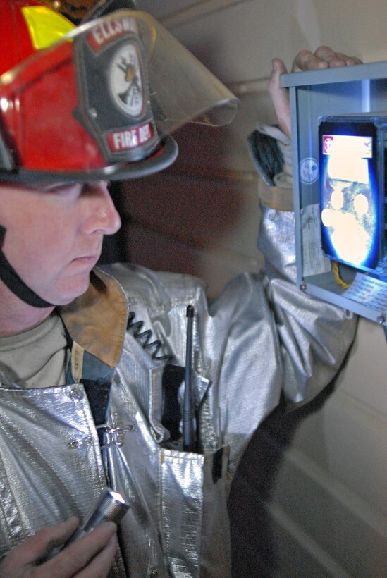 Tech. Sgt. David Rosss, 28th Civil Engineer Squadron fire fighter crew chief, monitors the internal temperature in the fire training burn house during a training exercise on Ellsworth April 19. Training burns are conducted regularly to ensure Ellsworth fire fighters maintain readiness and meet Federal Aviation Administration annual training requirements. (U.S. Air Force photo/ Senior Airman Marc Lane)