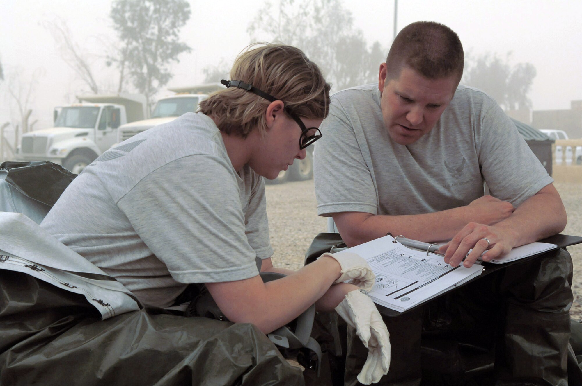 Staff Sgt. Amber Albano and Senior Master Sgt. Thomas Stoudt review response actions before investigating an unknown powdery substance in a building during a training event at Balad Air Base, Iraq, April 17. The unknown substance scenario was one of many that Airmen from Balad AB, Kirkuk Regional AB, Ali Base, and Al Asad Airfield participated in during a week-long emergency management training session which concluded April 19. Sergeant Albano is deployed to 506th Expeditionary Civil Engineer Squadron as an emergency manager at Kirkuk Regional AB. Sergeant Stoudt is deployed to Southwest Asia as the functional manager for the emergency management career field. (U.S. Air Force photo/Senior Airman Julianne Showalter)