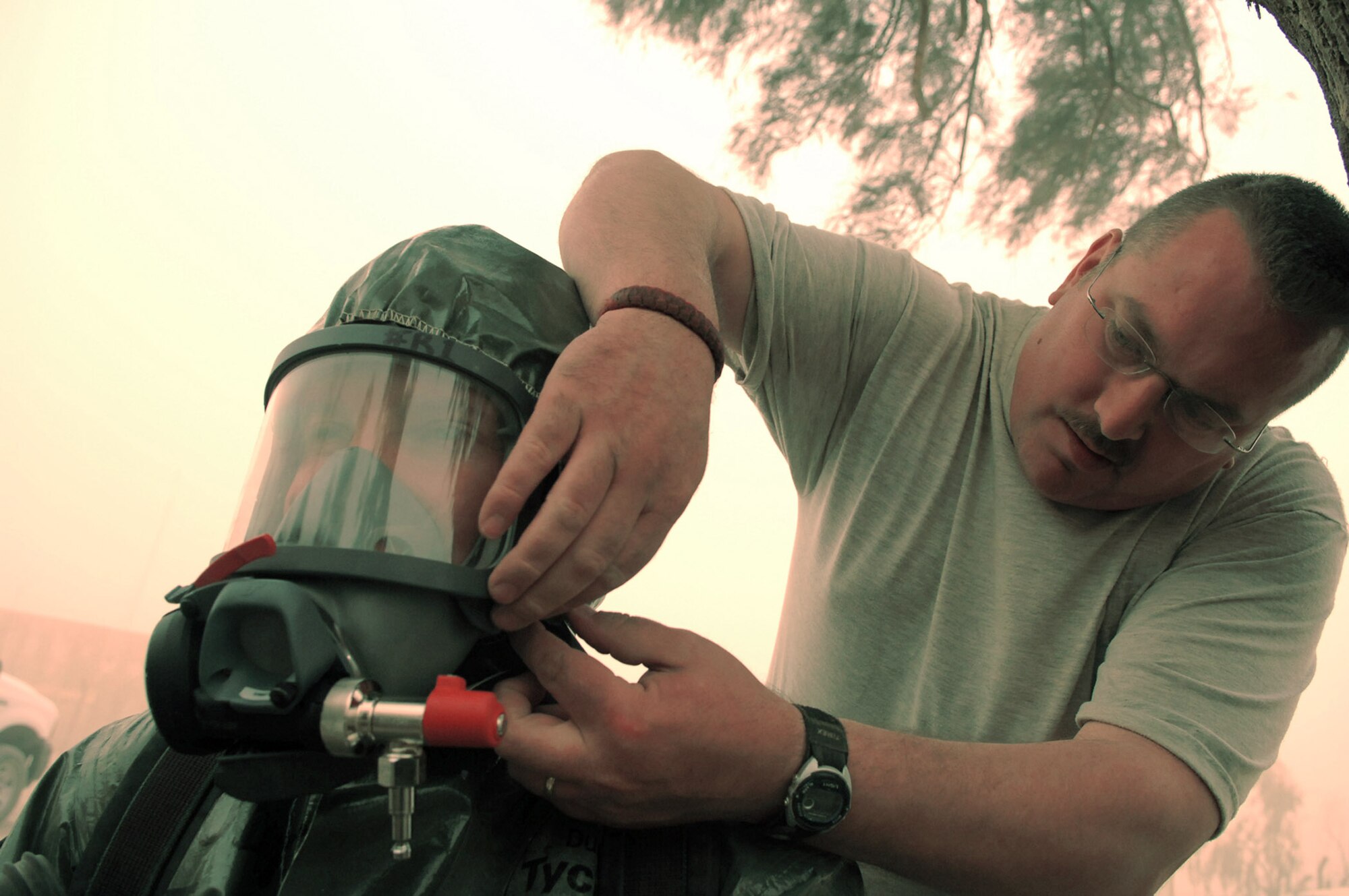 Master Sgt. Stephen Jakle helps Staff Sgt. Amber Albano put on her oxygen mask before she investigated an unknown powder substance during a training scenario at Balad Air Base, Iraq, April 17. The suits worn by the Airmen allow them to respond to real world situations and can protect against chemical, biological, radiological and nuclear materials. Being confident and comfortable with their equipment allows emergency managers to focus on the task at hand. Sergeant Jakle is deployed to the 407th Expeditionary Civil Engineer Squadron as an emergency manager at Ali Base, Iraq. Sergeant Albano is deployed to the 506th Expeditionary Civil Engineer Squadron as a emergency manager at Kirkuk Regional AB, Iraq. (U.S. Air Force photo/Senior Airman Julianne Showalter)