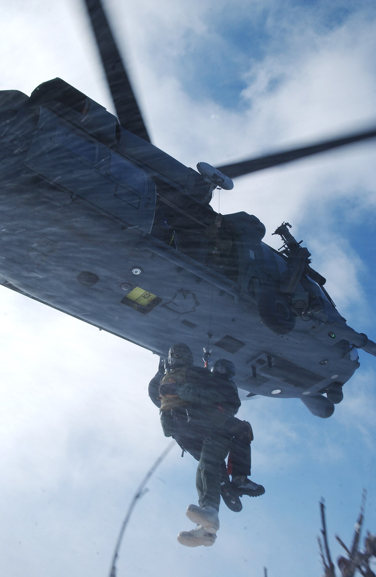 A survival, evasion, resistance and escape specialist extracts 1st Lt. Alex Goldberg from hostile location in a HH-60 Pavehawk during evasion and survival training April 16, 2008, at Eielson Air Force Base, Alaska. Lieutenant Goldberg is simulating as a downed pilot behind enemy lines and must communicate with the 33rd Rescue Squadron for extraction. Lieutenant Goldberg is a pilot of the 61st Fighter Squadron from Luke Air Force Base, Ariz. (U.S. Air Force Photo/Airman 1st Class Jonathan Snyder)