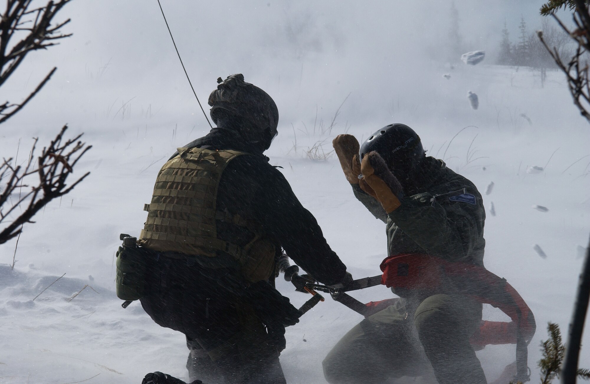 A survival, evasion, resistance and escape specialist, left, secures 1st Lt. Alex Goldberg, right, to be lifted up into a HH-60 during RED FLAG-Alaska 08-2 April 16, 2008, at Eielson Air Force Base, Alaska. Lieutenant Goldberg is simulating as a downed pilot behind enemy lines and must communicate with the 33rd Rescue Squadron for extraction. Lieutenant Goldberg is a pilot of the 61st Fighter Squadron from Luke Air Force Base, Ariz. (U.S. Air Force Photo/Airman 1st Class Jonathan Snyder)