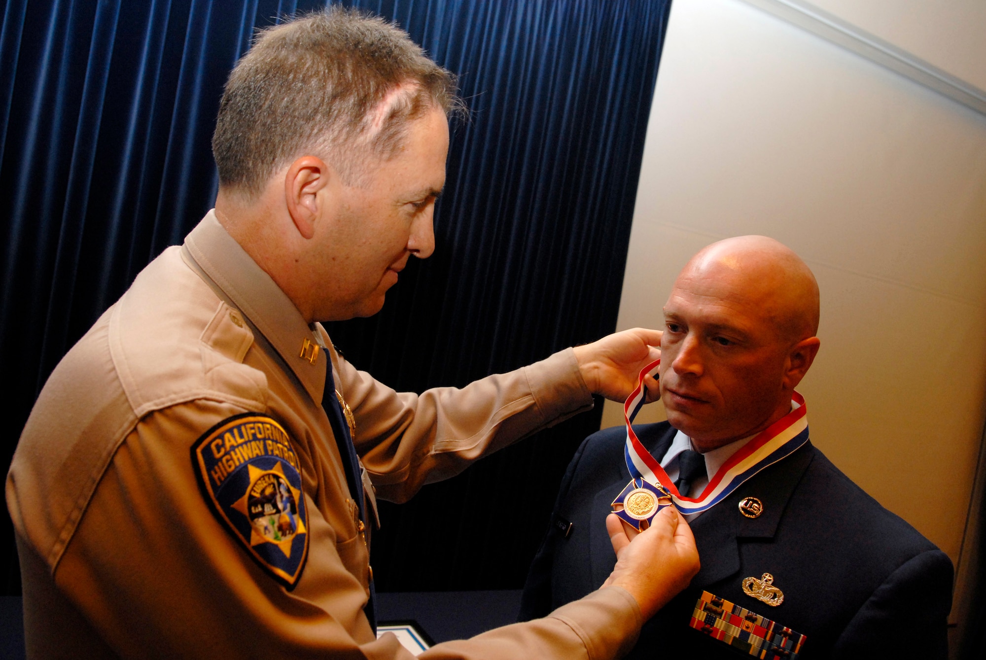 SIMI VALLEY, Calif. -- Capt. Cliff Williams, California Highway Patrol commander, presents Tech. Sgt. James Dusenberry, a 30th Security Forces Squadron member, with the Medal of Valor during the 35th Annual Awards Ceremony at the Ronald Reagan Presidential Library on April 19. The medal of valor is the highest award given to law enforcement officers who show extraordinary bravery above and beyond the call of duty. (U.S. Air Force photo/Airman 1st Class Christian Thomas) 
