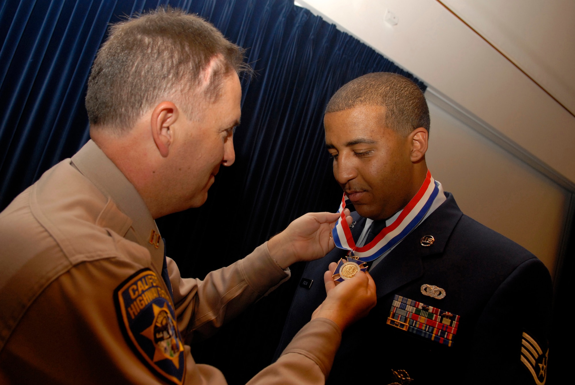 SIMI VALLEY, Calif. -- Capt. Cliff Williams, California Highway Patrol commander, presents Staff Sgt. Jason Brown, a 30th Security Forces Squadron member, with the Medal of Valor during the 35th Annual Awards Ceremony at  the Ronald Reagan Presidential Library on April 19. Sergeant Brown was recognized for saving the life of CHP Officer Tony Pedeferri at the scene of a major accident using self-aid buddy care and combat lifesaver training he had recently received as part of his 14-month deployment to Iraq. The Medal of Valor is the highest award given to law enforcement officers who show extraordinary bravery above and beyond the call of duty. (U.S. Air Force photo/Airman 1st Class Christian Thomas) 
