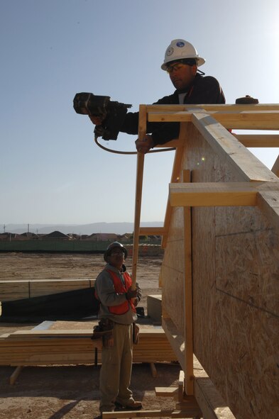 HOLLOMAN AIR FORCE BASE, N.M. -- Jonathon Rodriguez holds a piece of wood for Louis Morales to nail into place April 17. Both men are carpenters and are doing their part in the framing of 50 new homes here. (U.S. Air Force photo by Airman Sondra M. Wieseler)