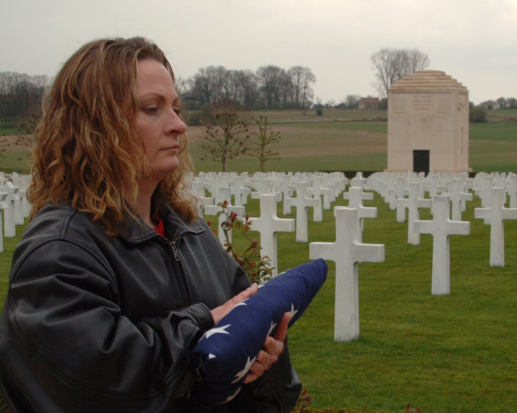 JAC Army Element First Sergeant Melissa A. O'Brien presents the folded flag at the conclusion of the end of day flag lowering ceremony at the American Somme Cemetary and Monument.  (U.S. Air Fore photo by Staff Sgt. Chad E. Chisholm)