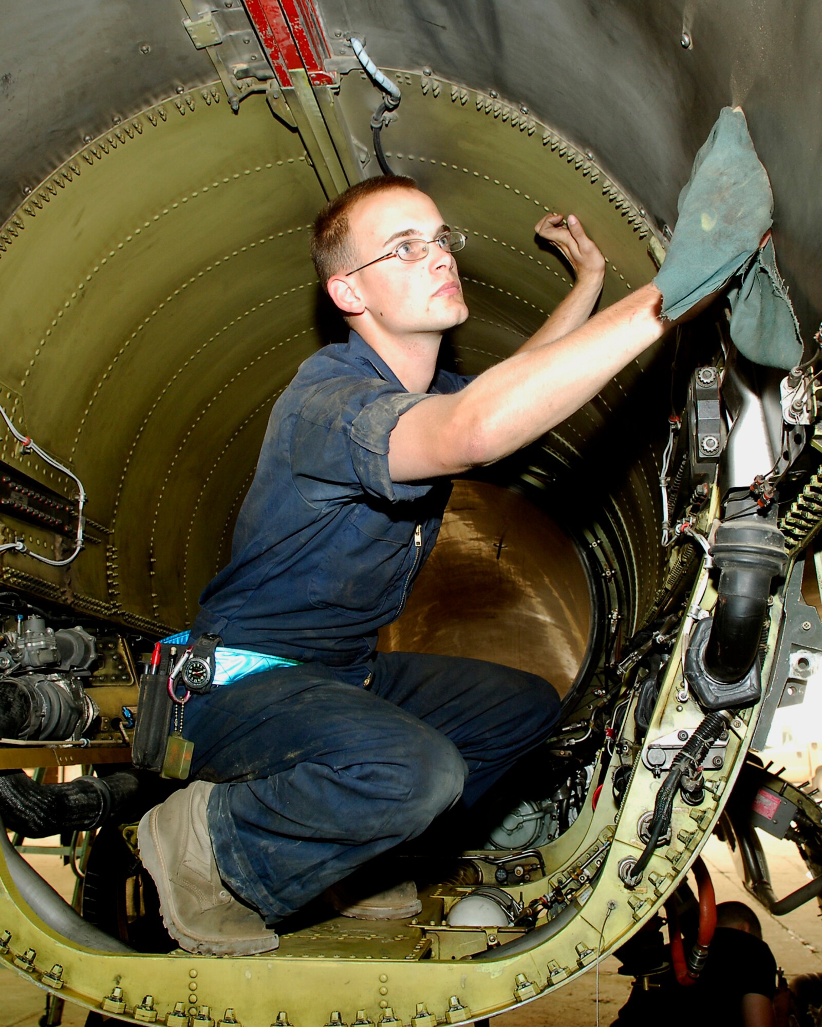 BALAD AIR BASE, Iraq -- Airman 1st Class Joseph Miller, 332nd Aircraft Maintenance Squadron F-16 Fighting Falcon crew chief, wipes down the inside of an F-16 Fighting Falcon here, April 19. Aircraft maintainers work around the clock performing scheduled maintenance and inspections on aircraft and making necessary repairs to keep the jets in top flying condition. Airman Miller is deployed from Spangdahlem Air Base, Germany. (U.S. Air Force photo /Staff Sgt. Mareshah Haynes)
