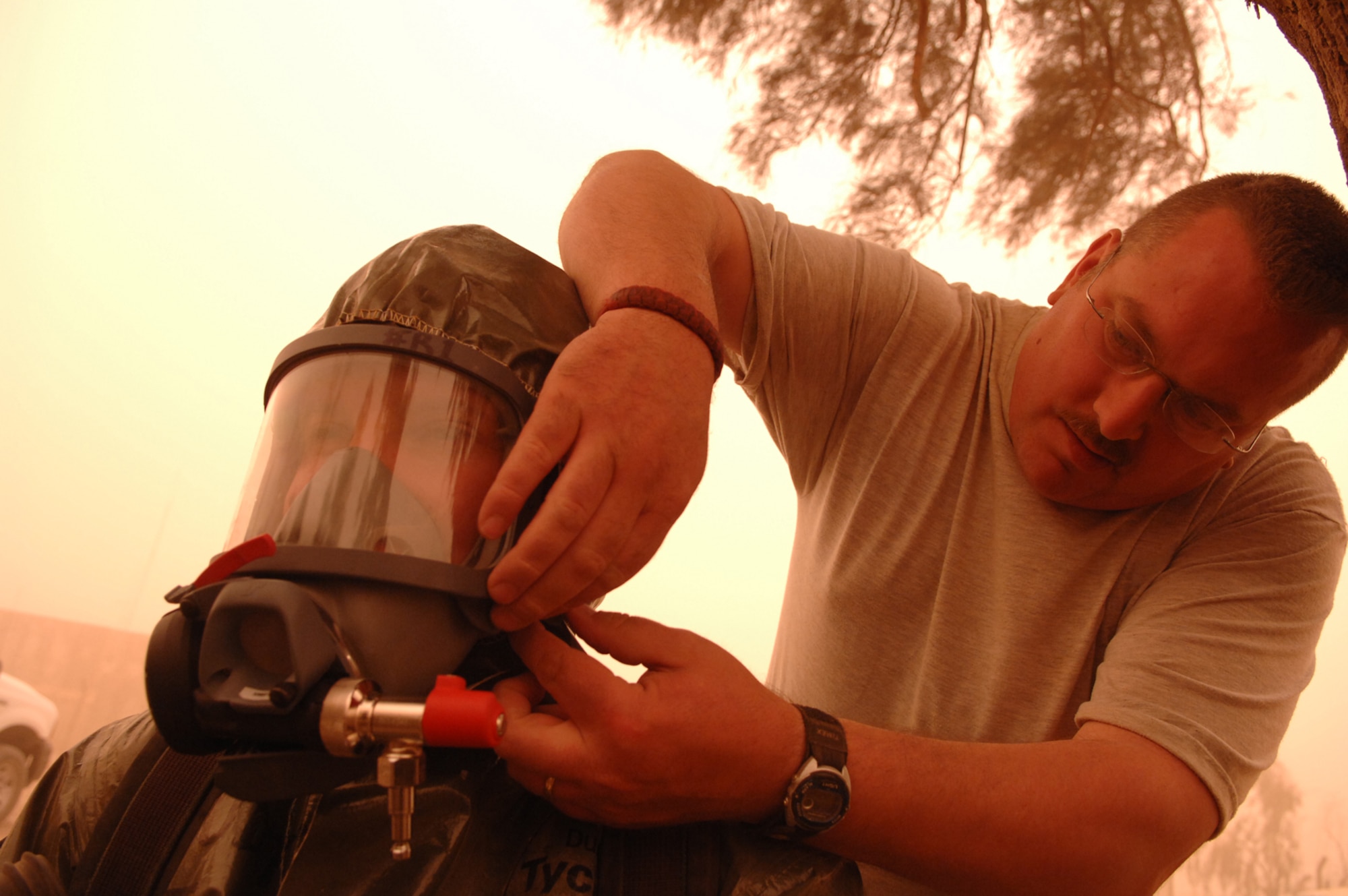 BALAD AIR BASE, Iraq -- Master Sgt. Stephen Jakle (right), 407th Expeditionary Civil Engineer Squadron emergency manager from Ali Base, helps Staff Sgt. Amber Albano, 506th Expeditionary Civil Engineer Squadron emergency manager from Kirkuk Regional Air Base, put on her oxygen mask before she investigated an unknown powder substance during a training scenario here, April 17. The suits worn by the team members allow them to respond to real world situations and can protect against chemical, biological, radiological and nuclear materials. Being confident and comfortable with their equipment allows emergency managers to focus on the task at hand. Sergeant Jakle is deployed from the Michigan Air National Guard; Sergeant Albano is deployed from Beale Air Force Base, Calif. (U.S. Air Force photo/ Senior Airman Julianne Showalter)