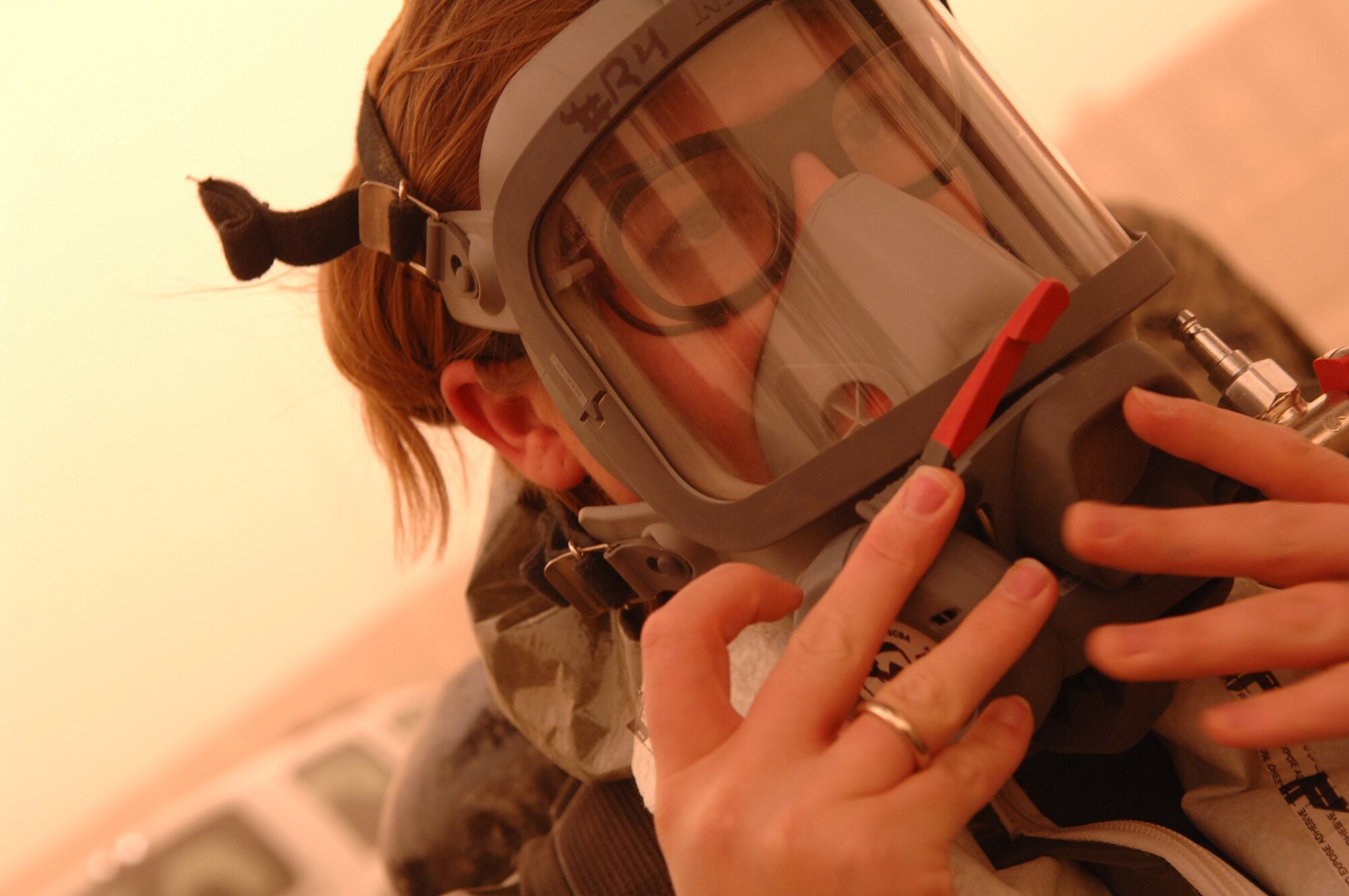 BALAD AIR BASE, Iraq -- Staff Sgt. Amber Albano, 506th Expeditionary Civil Engineer Squadron emergency manager from Kirkuk Regional Air Base, adjusts her oxygen mask before investigating an unknown powder substance during a training scenario here, April 17. Airmen from all over the area of responsibility came to Balad Air Base for a week-long emergency management training session that concluded April 19. Sergeant Albano is deployed from Beale Air Force Base, Calif. (U.S. Air Force photo/ Senior Airman Julianne Showalter)