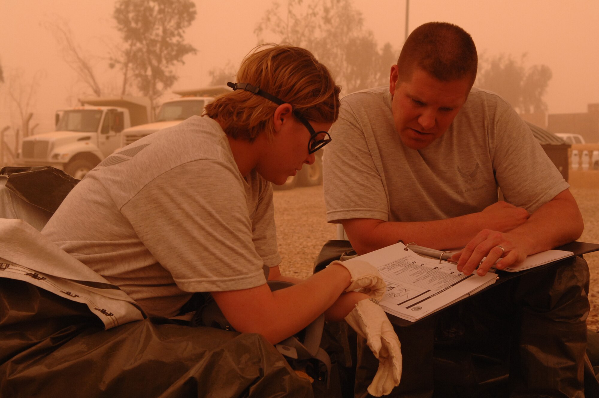 BALAD AIR BASE, Iraq -- Staff Sgt. Amber Albano, 506th Expeditionary Civil Engineer Squadron emergency manager from Kirkuk Regional Air Base, and Senior Master Sgt. Thomas Stoudt, deployed to Southwest Asia as the functional manager for the emergency management career field, review response actions before investigating an unknown powdery substance in a building here during a training event, April 17. The unknown substance scenario was one of many that Airmen from Balad, Kirkuk, Ali Base, and Al Asad Airfield participated in during a week-long emergency management training session that concluded April 19. Sergeant Albano is deployed from Beale Air Force Base, Calif.; Sergeant Stoudt is deployed from Air National Guard Headquarters, Washington D.C. (U.S. Air Force photo/ Senior Airman Julianne Showalter)