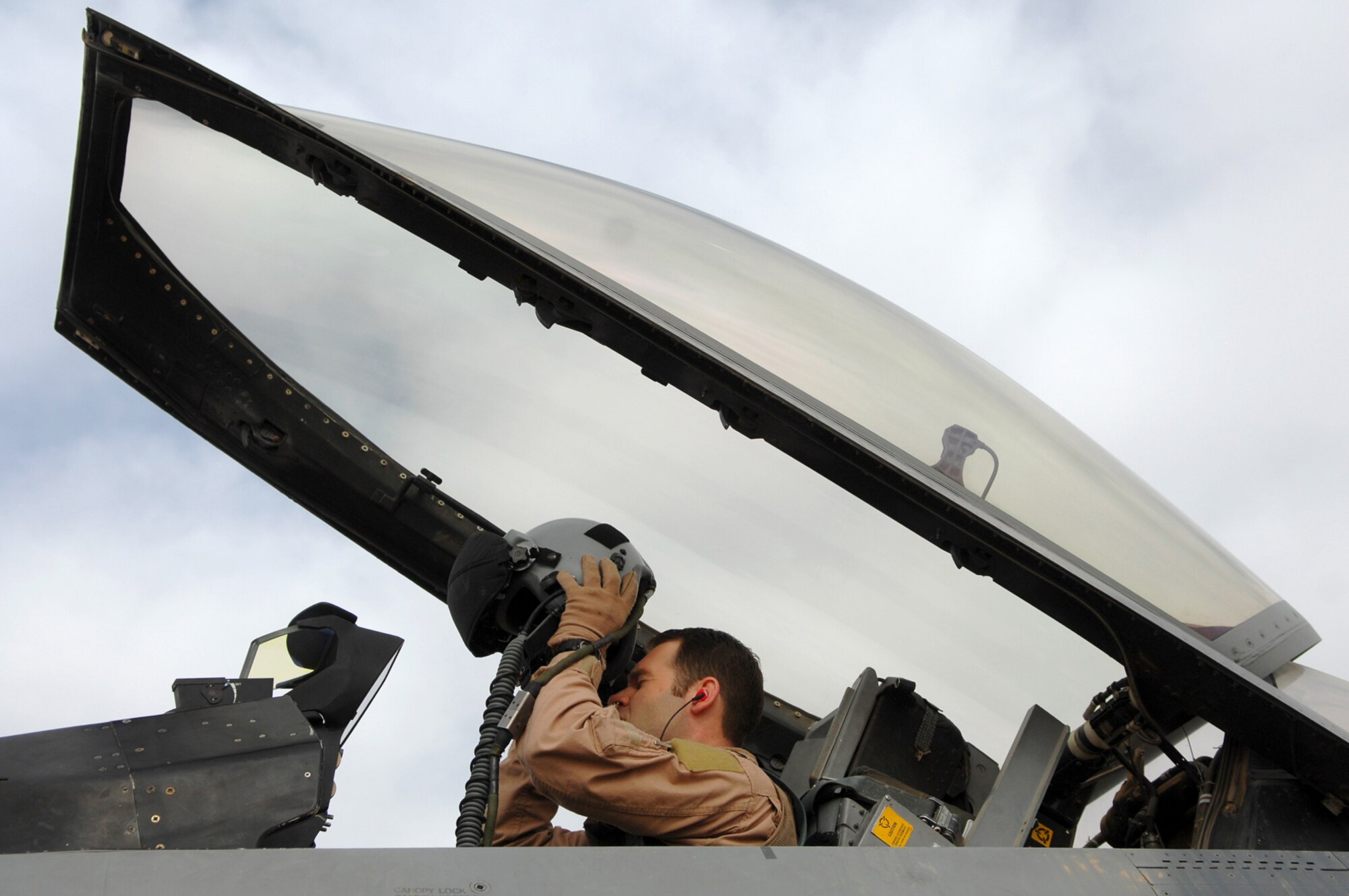 BALAD AIR BASE, Iraq -- Capt. D., 421st Expeditionary Fighter Squadron pilot, dons his helmet before take off here, April 18. His mission contributed to an important milestone for the U.S. Air Force -- 1 million sorties flown in support of the Global War on Terrorism, which occurred April 20. Captain D. is deployed from Hill Air Force Base, Utah. (U.S. Air Force photo/ Senior Airman Julianne Showalter) 