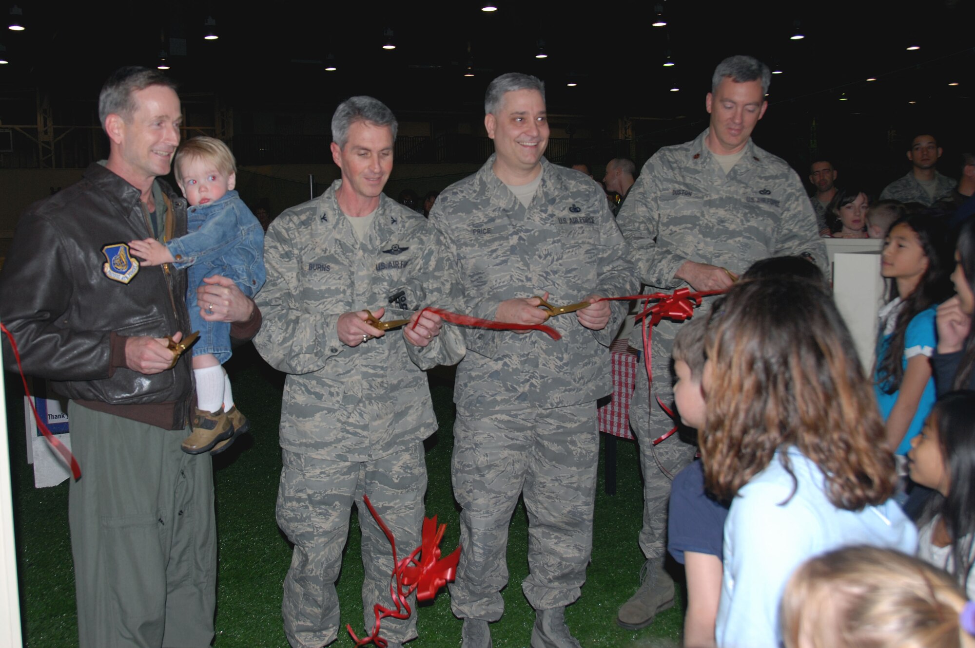 From left to right: Col. T.J. O’Shaughnessy, 35th Fighter Wing commander, with son Sammy, Col. Mark Burns, Mission Support commander, Chief Master Sgt. Ricky Price, 35th Fighter Wing command chief, and Maj. Matthew Duston, Civil Engineer Squadron Operations flight commander, cut the ribbon to mark the opening of the new Weasel’s Den playground April 18, 2008. (U.S. Air Force photo by Senior Airman Stefanie Torres)
