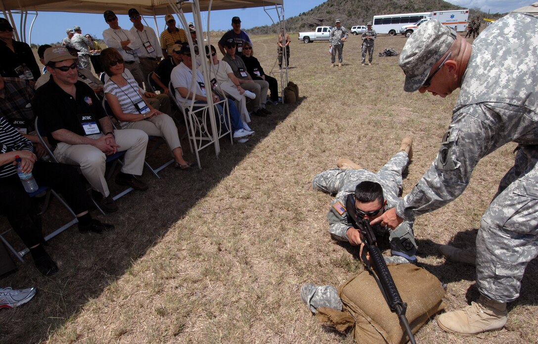 A U.S. Army military policeman, center, briefs members from the 75th Joint Civilian Orientation Conference on firing  an M16 rifle during a weapons familiarization course, Guantanamo Naval Base, Cuba, April 19, 2008.