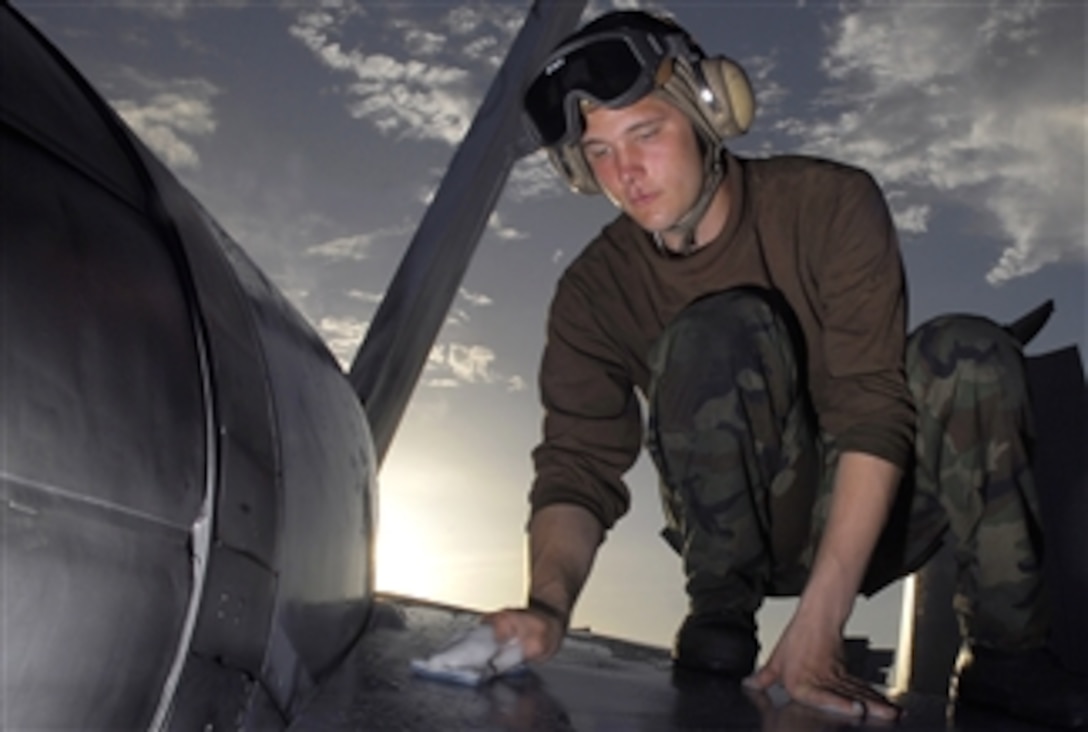 U.S. Air Force Airman Jonathan Honebrink cleans a trailing wing on an F/A-18C Hornet aboard the nuclear-powered aircraft carrier USS Nimitz, Pacific Ocean, April 19, 2008. 
